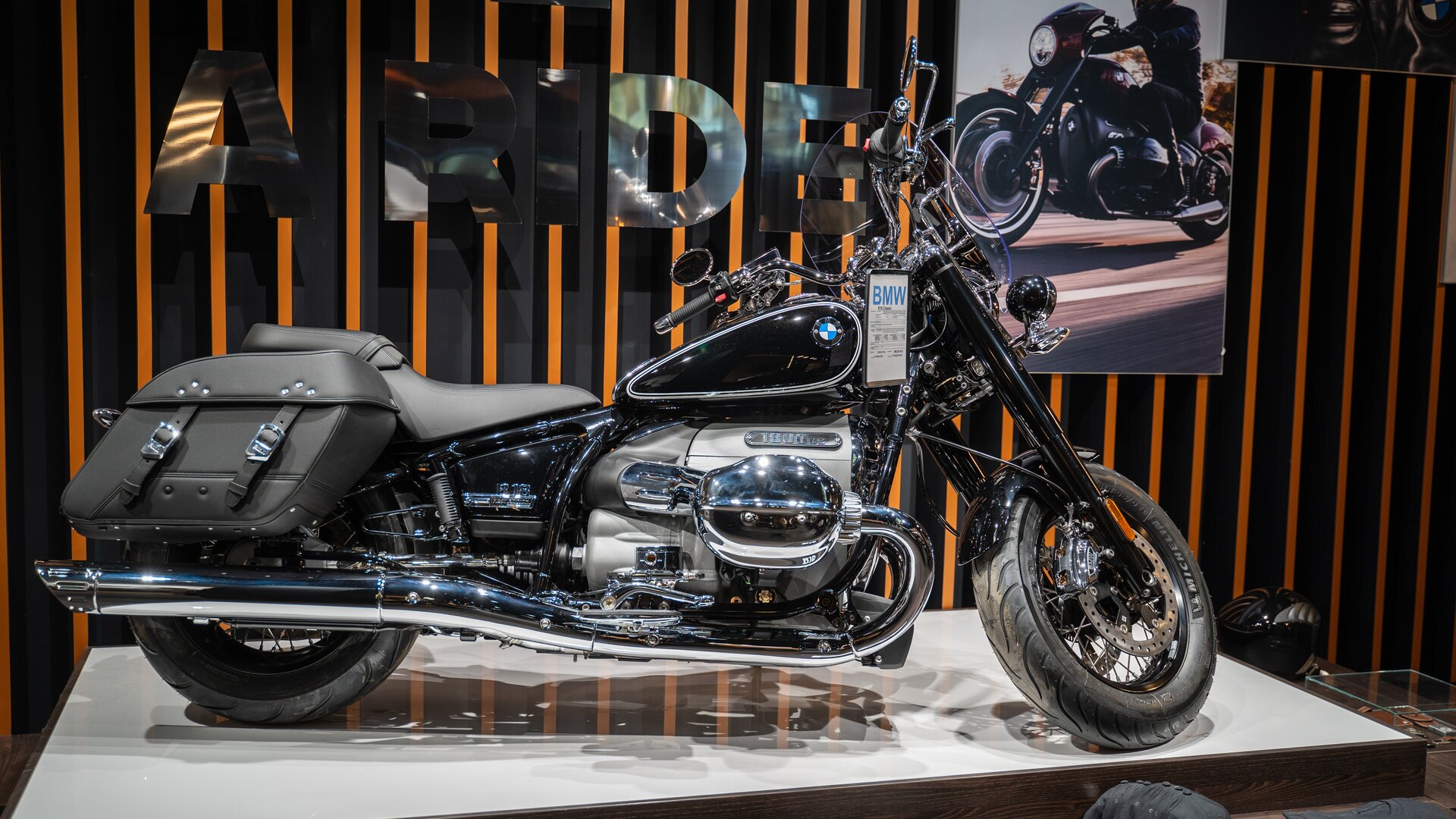 Zdjęcie przedstawia elegancki motocykl. Jest długi, srebrno‑czarny. Ma skórzane sakwy na wysokości tylnego koła.  