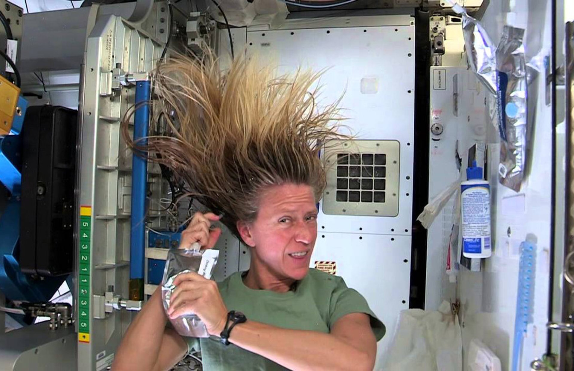 Rys. 1. Zdjęcie przedstawia astronautkę w statku kosmicznym znajdującym się na orbicie okołoziemskiej. Długie włosy astronautki unoszą się nad jej głową – stoją na sztorc.