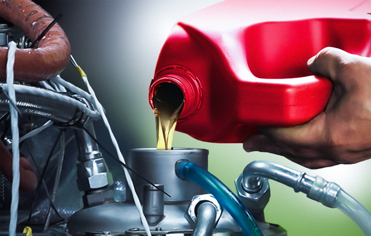 Zdjęcie przedstawia osobę, która uzupełnia olej silnikowy lotniczego silnika tłokowego. Jest on bezpośrednio wlewany do zbiornika przez odpowiedni wlew.