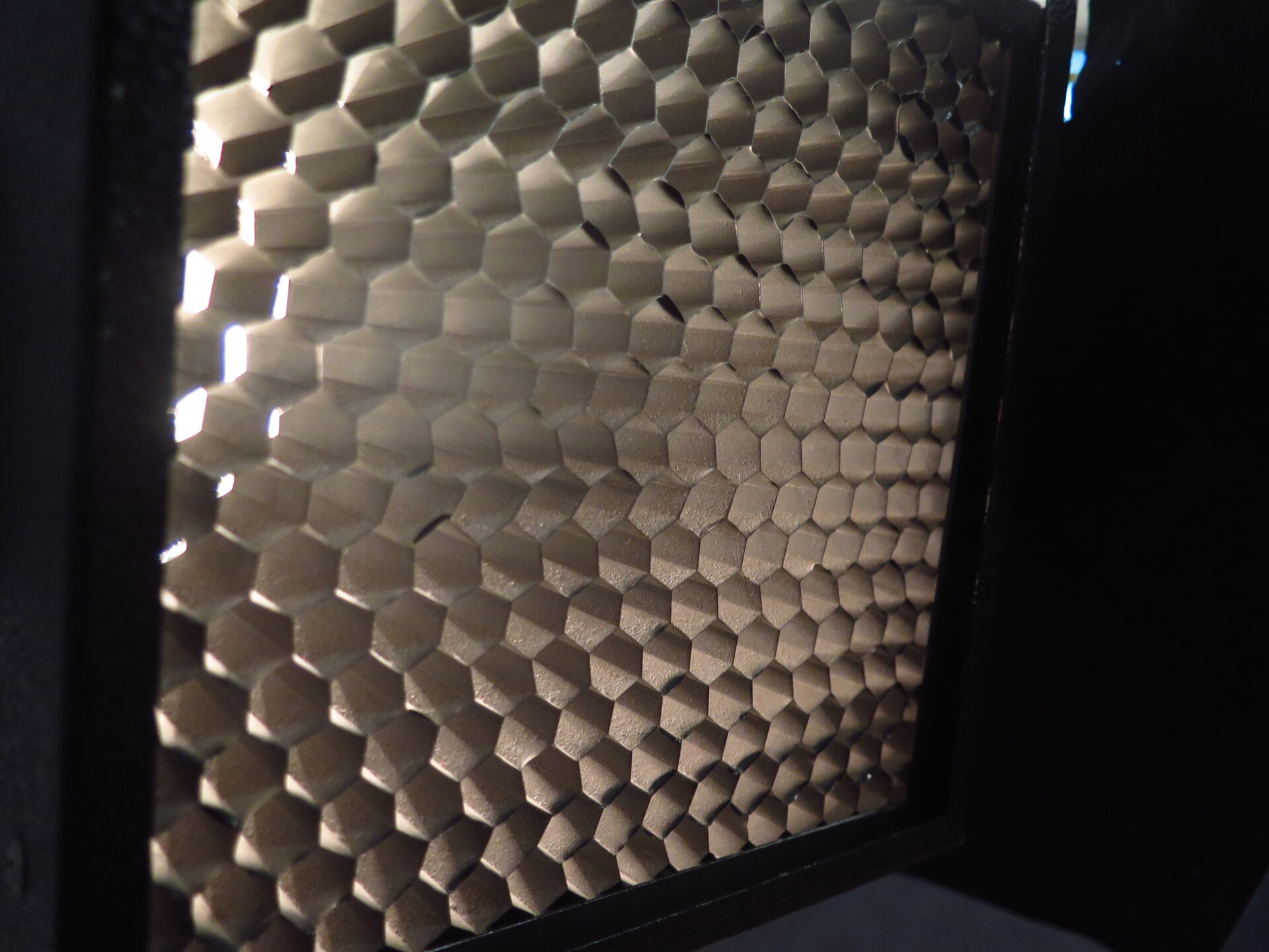 Zdjęcie przedstawia zbliżenie na strukturę modyfikatora o kształcie plastra miodu.