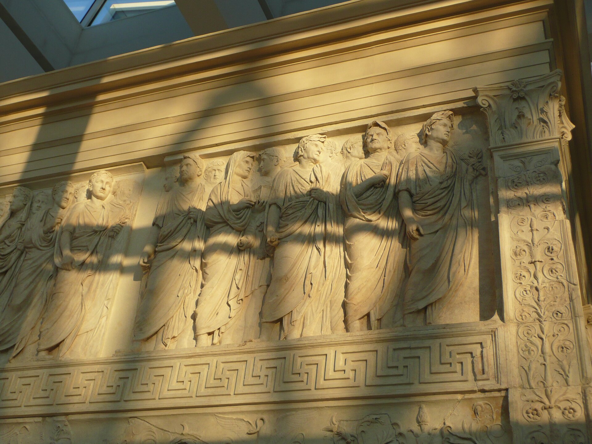 Fotografia przedstawia fragment ołtarza Pokoju Augustowego. Zdobiony jest płaskorzeźbą, na której wyrzeźbieni są mężczyźni w togach.