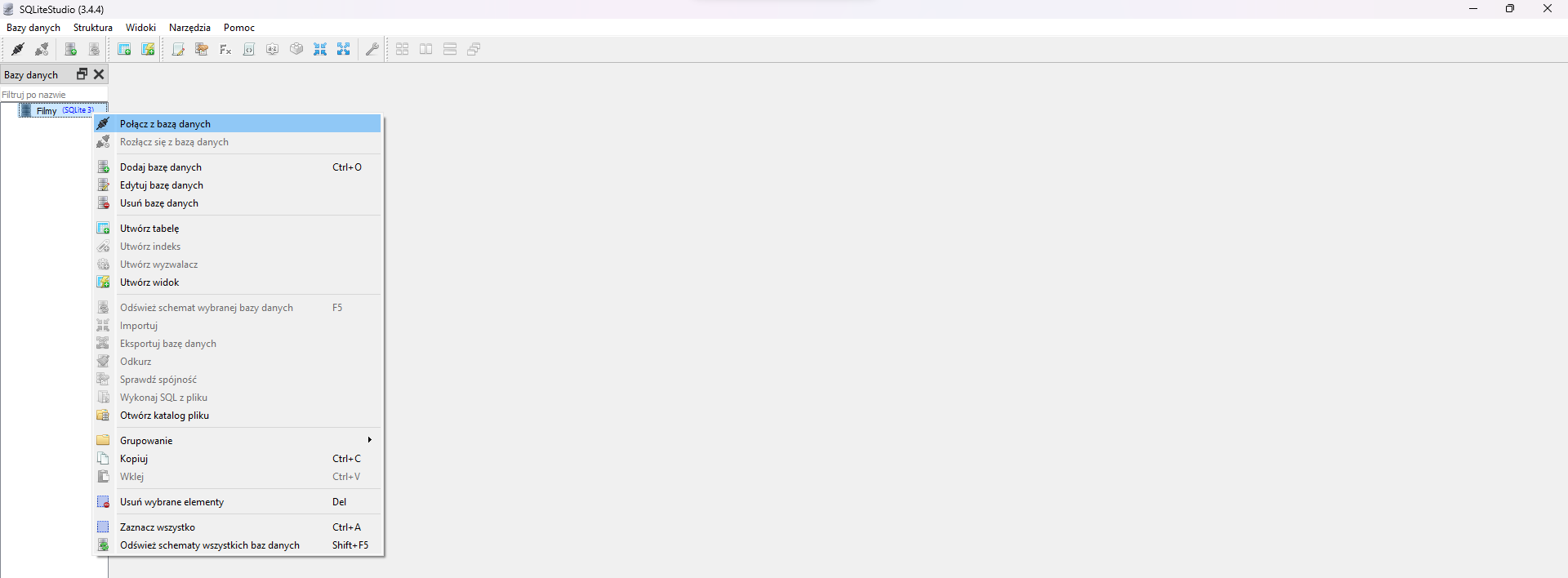 Na zdjęciu przedstawiono zrzut ekranu przedstawiający łączenie z bazą danych w programie SQL lite Studio.W górnej części okna aplikacji widoczny jest pasek narzędzi z następującymi opcjami: bazy danych, struktur, widoki, narzędzia, pomoc. Poniżej paska narzędzi znajdują się ikony. Ikony przedstawiają w kolejności: zapięte wtyczki, rozpięte wtyczki, serwer z zielonym znakiem plus, serwer z dwoma zielonymi strzałkami, bazę danych ze znakiem plus, bazę danych ze znakiem plus i błyskawicą, kartkę papieru z ołówkiem, serwer z dłonią trzymającą kartkę, Fx, kartka z dwoma nawiasami ostrymi skierowanymi na zewnątrz, element z literami AZ, klocek dwa na dwa, cztery strzałki w układzie kwadratu skierowane do wewnątrz, cztery strzałki w układzie kwadratu skierowane na zewnątrz, klucz, cztery kwadraty w układzie kwadratu, dwa podłużne pionowe prostokąty obok siebie, dwa podłużne poziome prostokąty obok siebie, trzy okna ustawione jedno za drugim. Poniżej aplikacja podzielona jest na dwa obszary. Małe okno po lewej stronie ma tytuł: Bazy danych. Obok tytułu znajduje się znak powiększenia okna oraz zamknięcia. Poniżej znajduje się pole wyszukiwania. Na polu widoczny jest napis: filtruj po nazwie. Niżej widoczna jest utworzona baza danych: filmy. Po naciśnięciu na nią prawym klawiszem myszy pojawia sięmenuwyboru  w formie listy. Kolejne pozycje listy: połącz z bazą danych, rozłącz się z bazą danych, dodaj bazę danych, edytuj bazę danych, usuń bazę danych, utwórz tabelę, utwórz indeks, utwórz wyzwalacz, utwórz widok, odśwież schemat wybranej bazy danych, importuj, eksportuj bazę danych, odkurz, sprawdź spójność, wykonaj SQL z pliku, otwórz katalog z pliku, grupowanie, kopiuj, wklej, usuń wybrane elementy, zaznacz wszystko, odśwież schematy wszystkich baz danych. Opcja połącz z bazą danych jest podświetlona.W prawej części okna znajduje się właściwy obszar roboczy. 