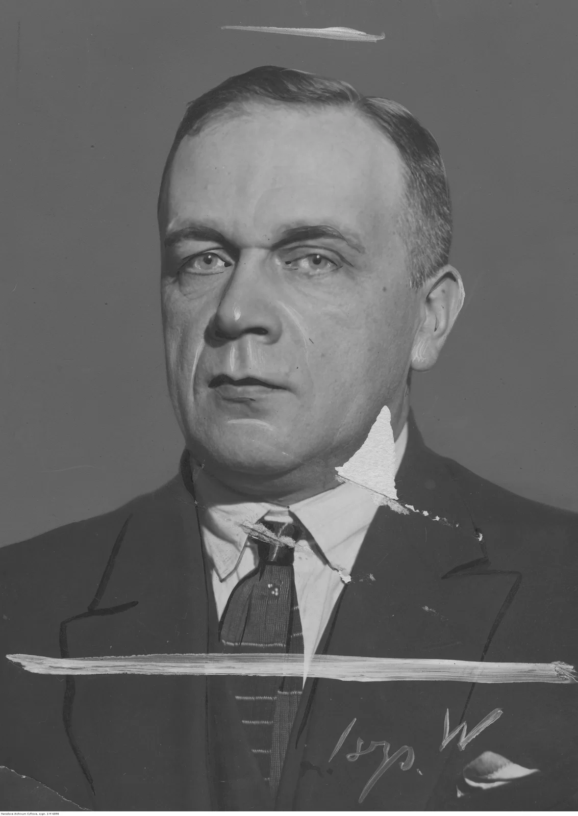 Ilustracja przedstawia portret Piotra Rytela - polskegoi kompozytora, pedagoga i krytyka muzycznego. Mężczyzna z poważną, nadąsaną miną. Włosy ma zaczesane na prawą stronę. Ubrany jest w białą koszulę, krawat i marynarkę.