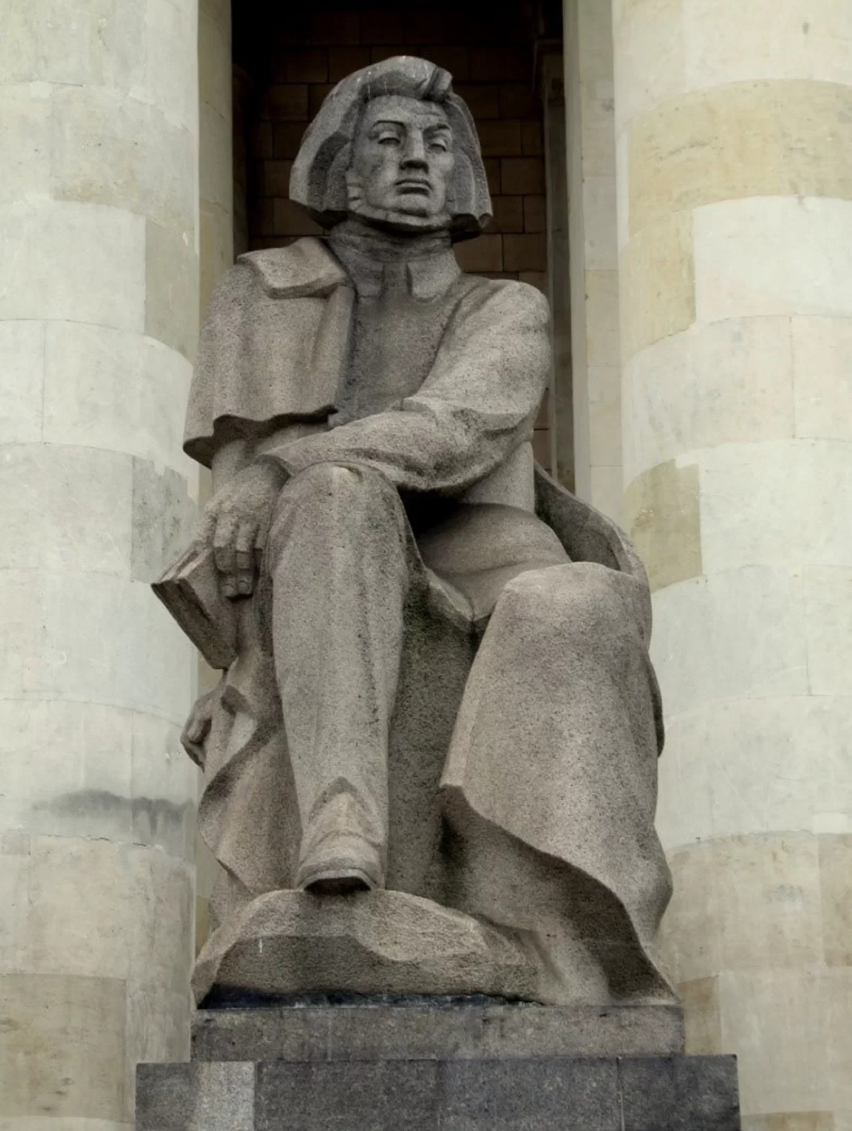 Rzeźba przedstawia siedzącego dumnie mężczyznę z dłuższymi włosami i brodą. Jest to Adam Mickiewicz. Mężczyzna trzyma książkę w lewej dłoni, którą trzyma na prawym kolanie.