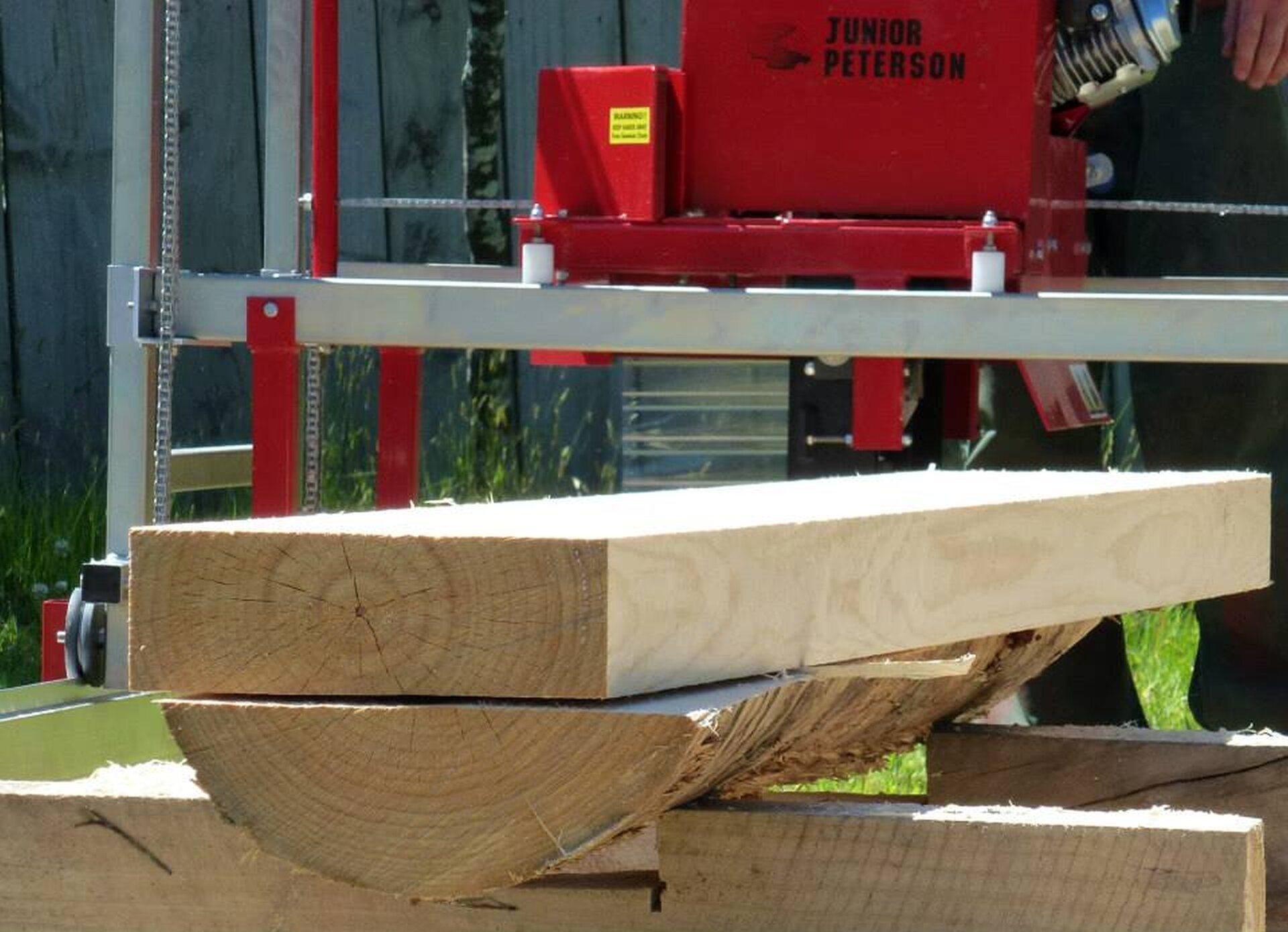 Kawałek drewna leżący na maszynie służącej do cięcia.