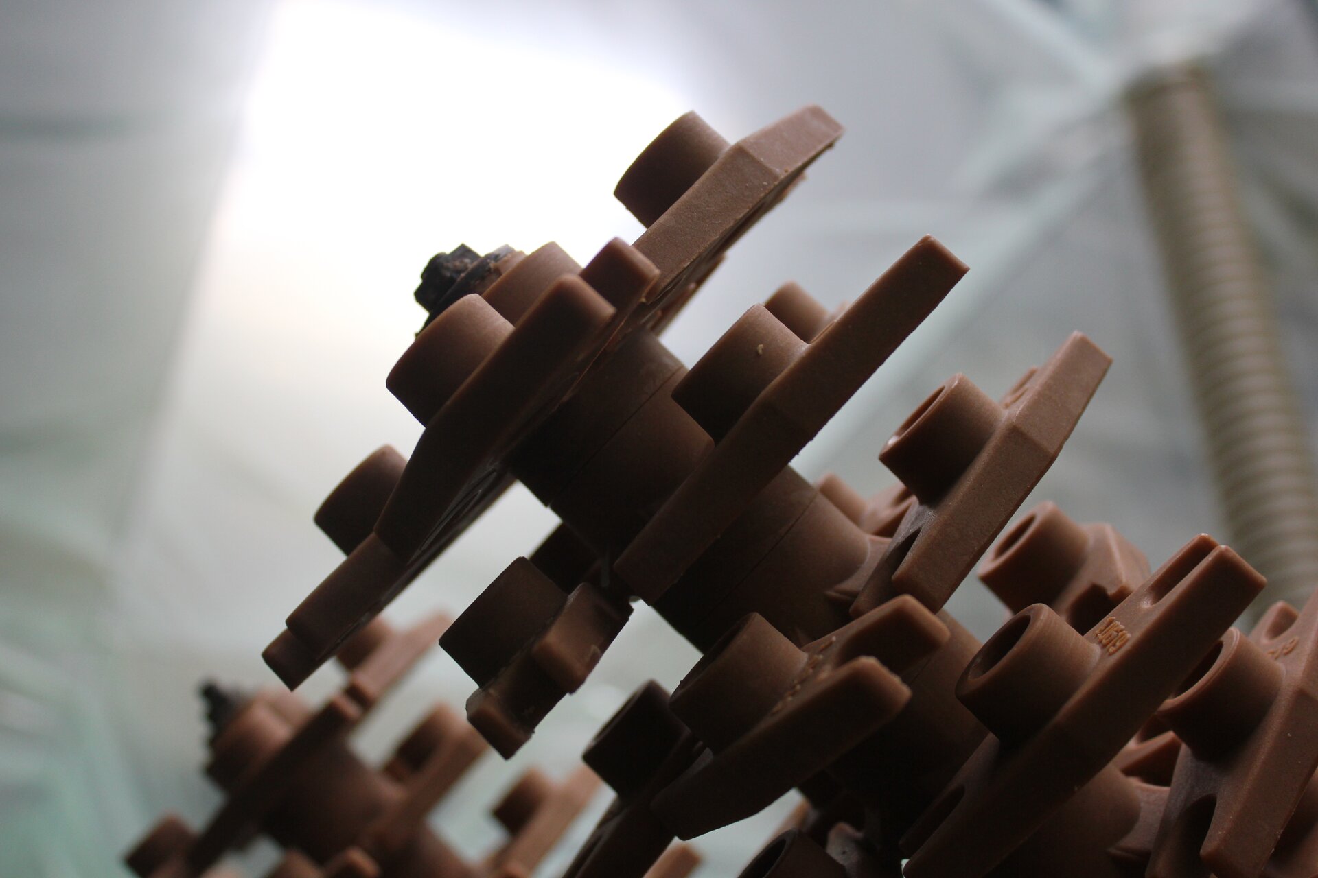 Ilustracja przedstawia słup z woskowymi modelami, przyczepionymi do niego. Tworzą one kształt przypominający choinkę.