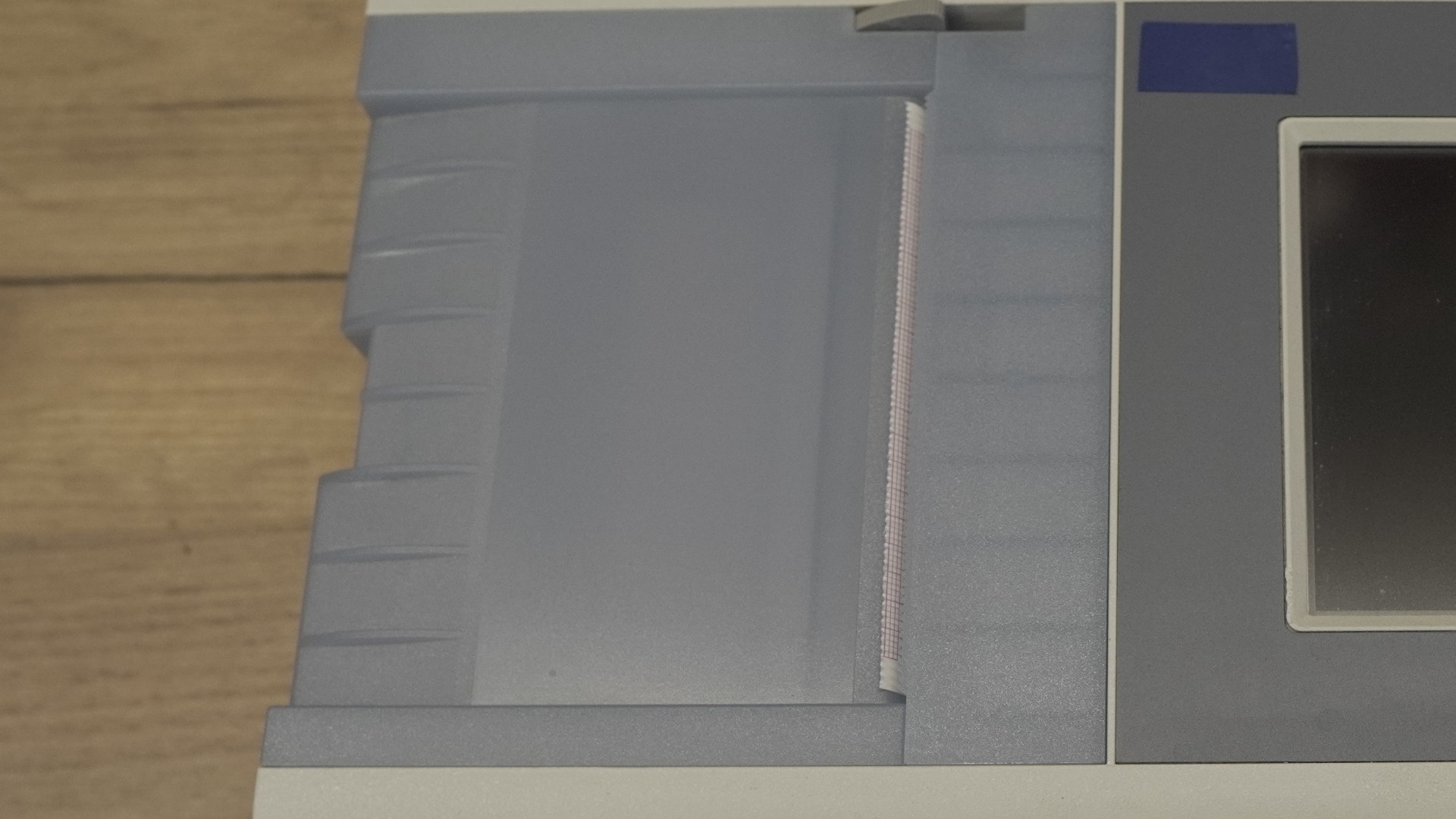 Zdjęcie przedstawia zbliżenie na drukarkę spirometru, znajdującą się po lewej stronie aparatu.