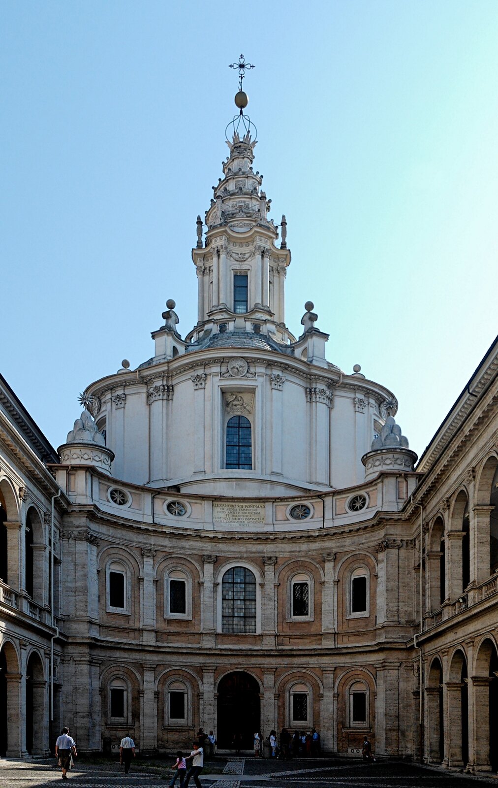 Ilustracja przedstawia kościół Sant’ Ivo della Sapienza w Rzymie Francesco Borrominiego. Ukazuje widok na fasadę zamkniętą placem, otoczonym arkadowymi loggiami. W centrum znajduje się wklęsły łuk fasady, smukła latarnia nad kopułą o bogatych zdobieniach rzeźbiarskich. Kompozycja bryły jest zwarta, symetryczna i rytmiczna. Rytm pojawia się w układzie okien. Kondygnacje dzieli gzyms.