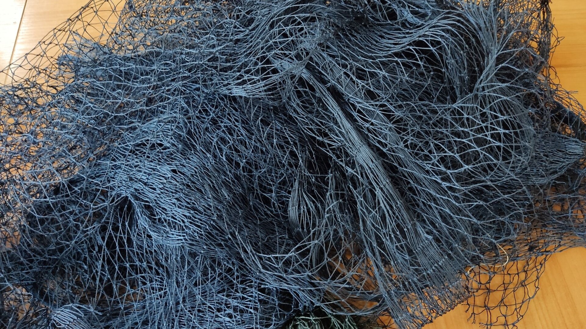 Zdjęcie przedstawia tkaninę sieciową ułożoną na stole.