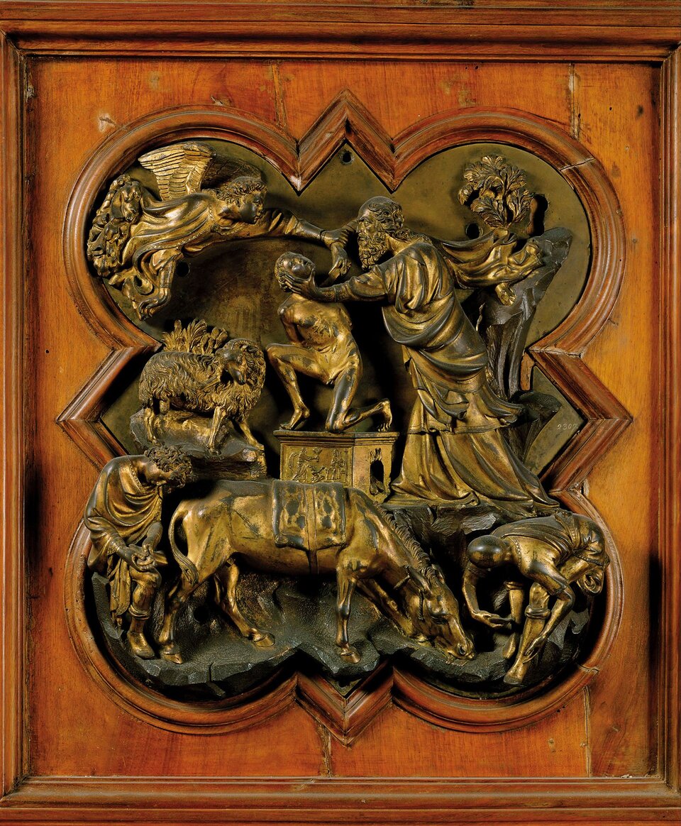 Ilustracja przedstawia dzieło Filippo Brunelleschi pt. „Ofiarowanie Izaaka”. Na fragmencie drzwi baptysterium florenckiego widzimy rzeźbę ze sceną ofiarowania Izaaka - mężczyzny klęczącego na posagu. Obok niego stoi starszy mężczyzna w szatach. Jedną ręką chwyta szyję młodzieńca, natomiast w drugiej ręce trzyma nóż, który zbliża do gardła Izaaka. Nad mężczyznami znajduje się anioł, który łapie starszego mężczyznę za rękę, w której trzyma nóź. Poniżej postaci znajdują się zwierzęta oraz inne postacie. Cała scena przedstawiona jest w brązowej ramie.