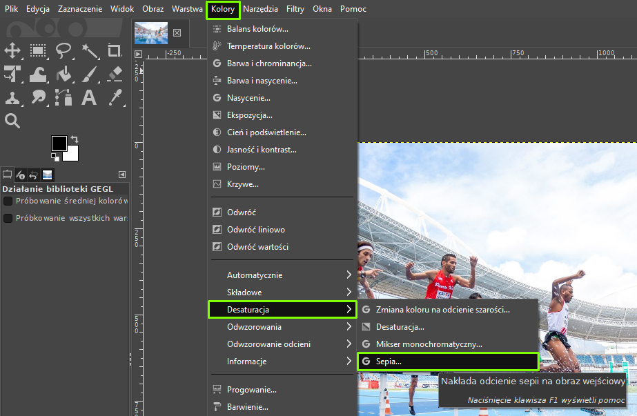 Ilustracja przedstawia okno programu. Z menu wybrano opcję Kolory, a następnie Desaturację, a w niej Sepię. Obok informacja: Nakłada odcienie sepii na obraz wejściowy. Po lewej stronie jest panel dotyczący Działania biblioteki GEGL. W obszarze roboczym jest kolorowe zdjęcie zawodników podczas biegu na stadionie.  