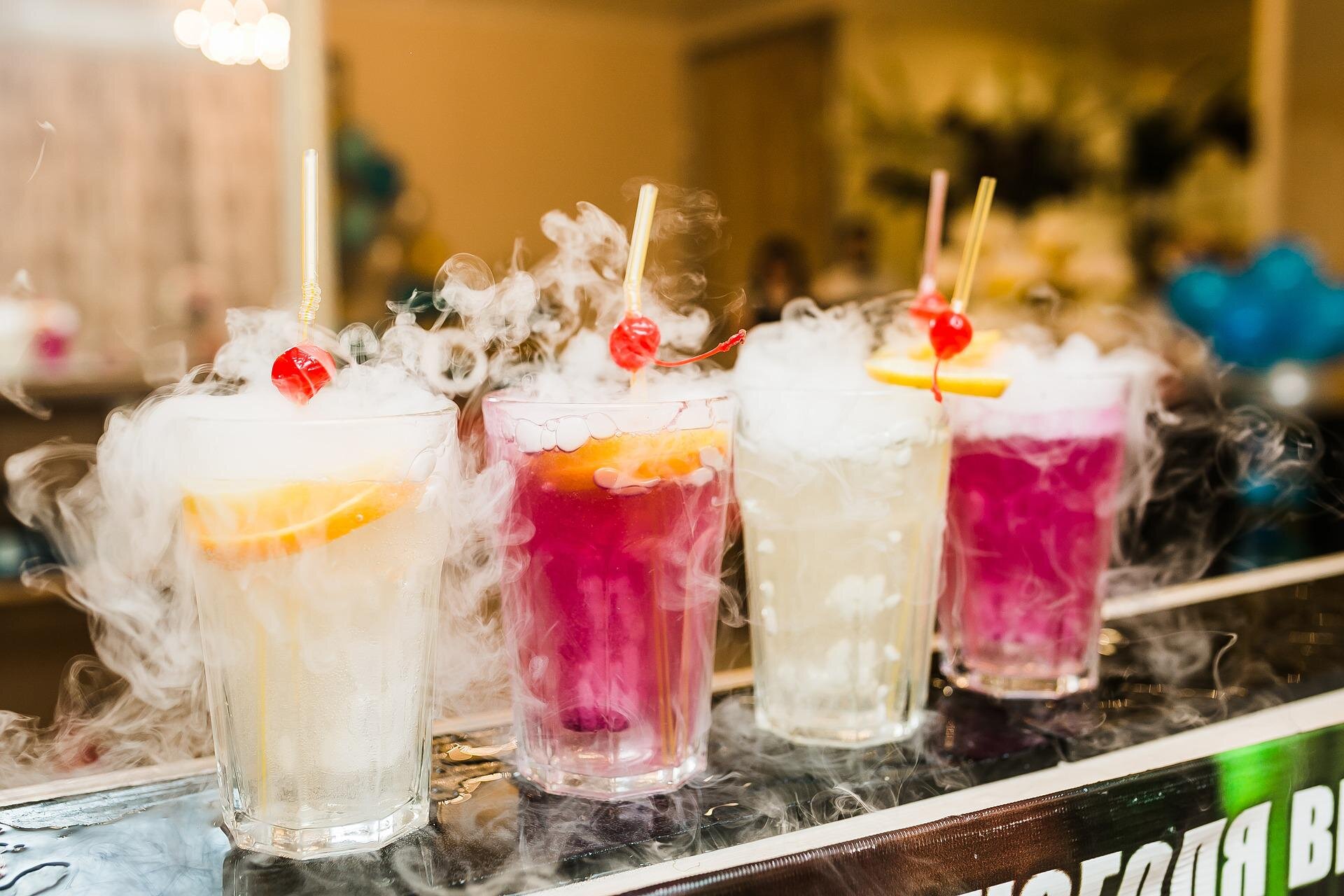 Ilustracja przedstawia cztery szklanki z napojami kolorowymi oraz ciekłym lodem.