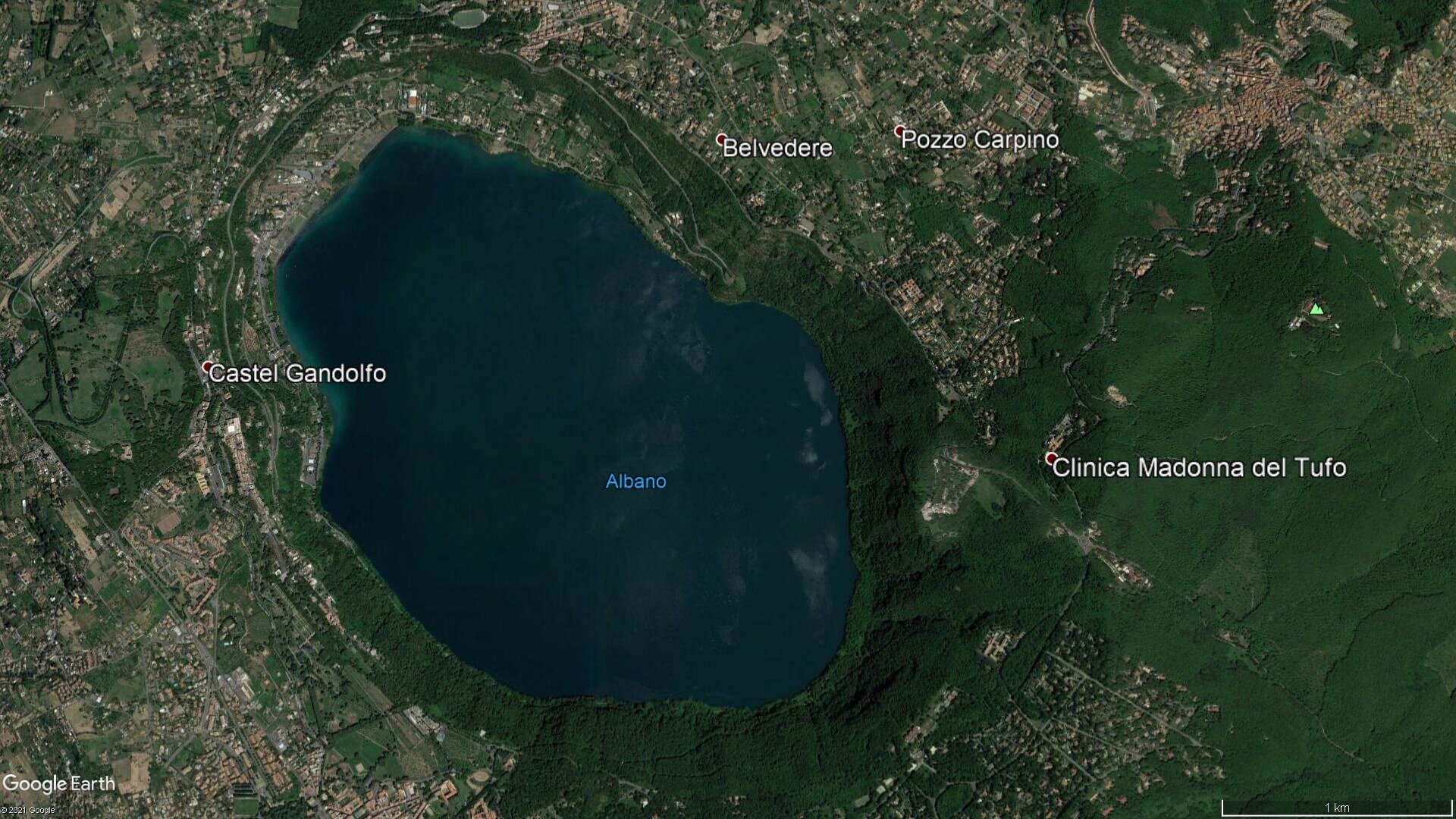 otografia wykonana z lotu ptaka przedstawia jezioro o owalnym kształcie. Jest wypełnione turkusową wodą. Jezioro podpisane jest jako Albano, obok niego zaznaczone są miejscowości Castel Gandolfo, Belvedere, Pozzo Carpino, Clinica Madonna del Tufo.