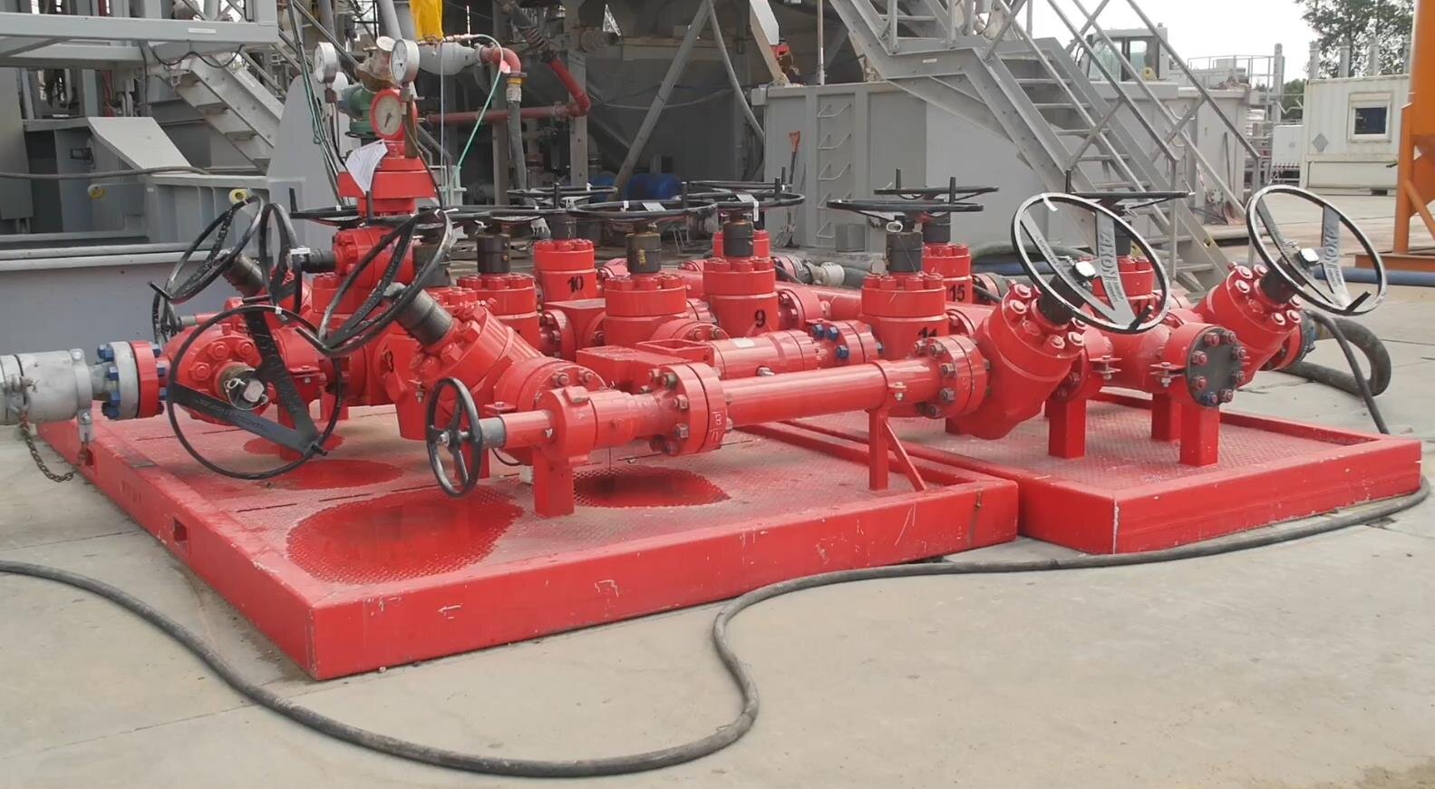 Na zdjęciu widoczny jest węzeł dławienia. Węzeł dławienia służy do tłumienia wypływu płynu złożowego z otworu. Na zdjęciu widoczna jest platforma, na której znajduje się duża ilość przewodów z zaworami. Z jednej strony do węzła prowadzą trzy przewody, a z drugiej znajduje się jeden większy przewód. Przy większym przewodzie znajdują się manometry. Węzeł dławienia posiada dużo więcej zaworów niż węzeł zatłaczania.