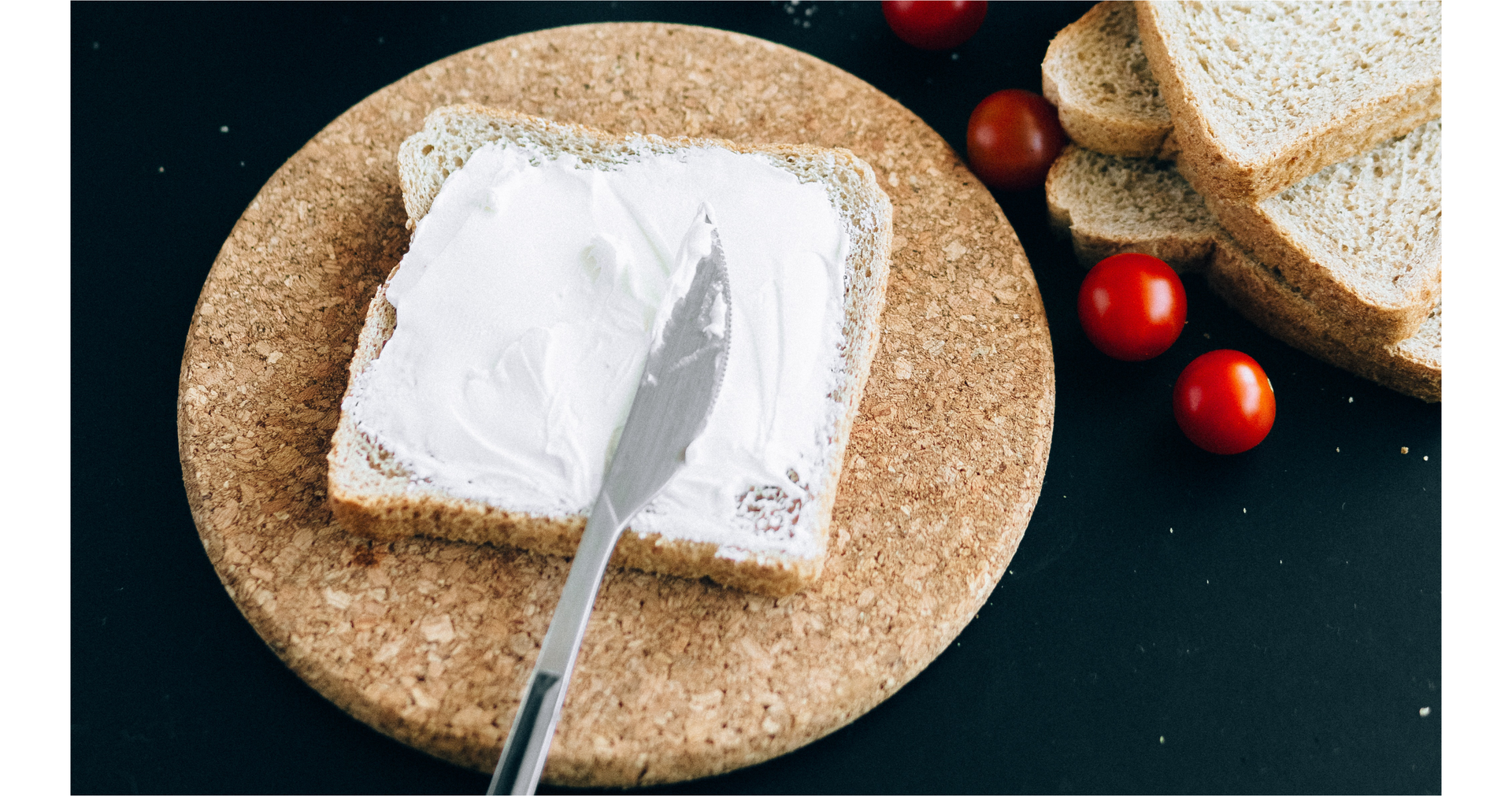 Zdjęcie przedstawia posmarowaną kromkę chleba. Na kromce leży nóż.