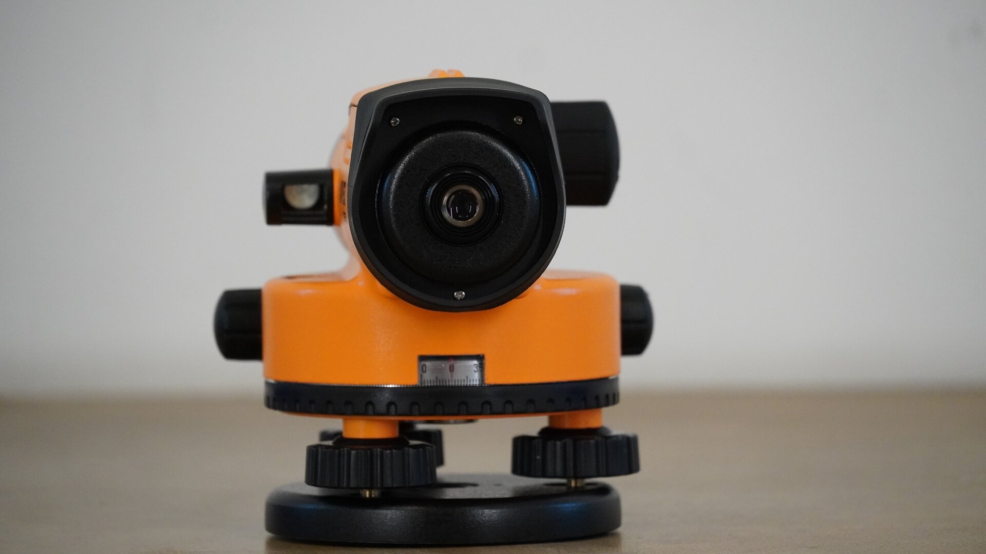 Na zdjęciu ukazano niwelator od strony okularu. Po lewej jego stronie widoczne jest lusterko libelli, a poniżej korpus z dwoma pokrętłami po bokach oraz podziałką koła poziomego poniżej. Pod kołem poziomym znajdują się trzy śruby umieszczone na okrągłej podstawie, czyli spodarce.