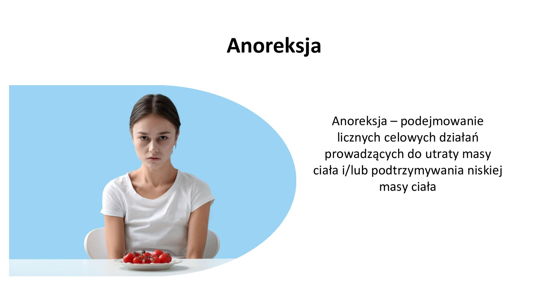 Biały slajd. Z lewej strony zdjęcie młodej kobiety siedzącej przy stole. Przed nią talerz z pomidorkami koktajlowymi. Kobieta wpatruje się w widza ze smutną miną. Z prawej strony slajdu tekst: „Anoreksja. Anoreksja - podejmowanie licznych celowych działań prowadzących do utraty masy ciała i/lub podtrzymywania niskiej masy ciała”.