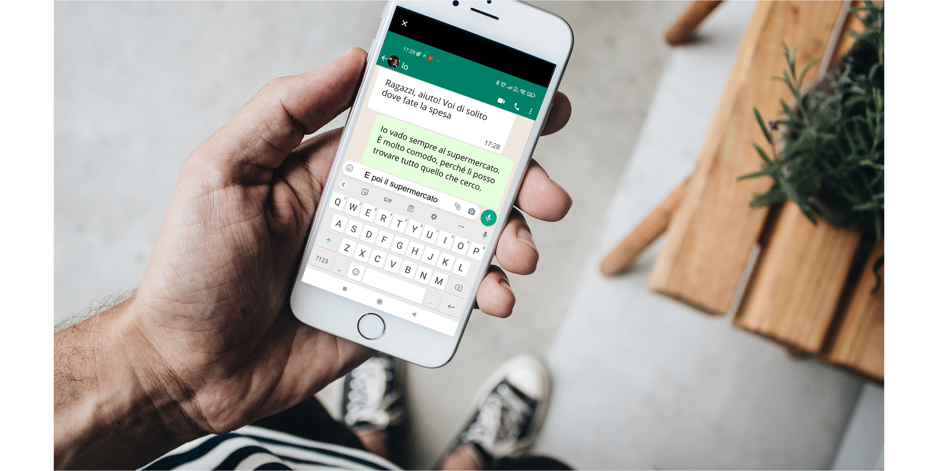 Zdjęcie przedstawia telefon komórkowy trzymany w dłoni jakiejś osoby. Na ekranie telefonu widoczny jest otwarty czat.