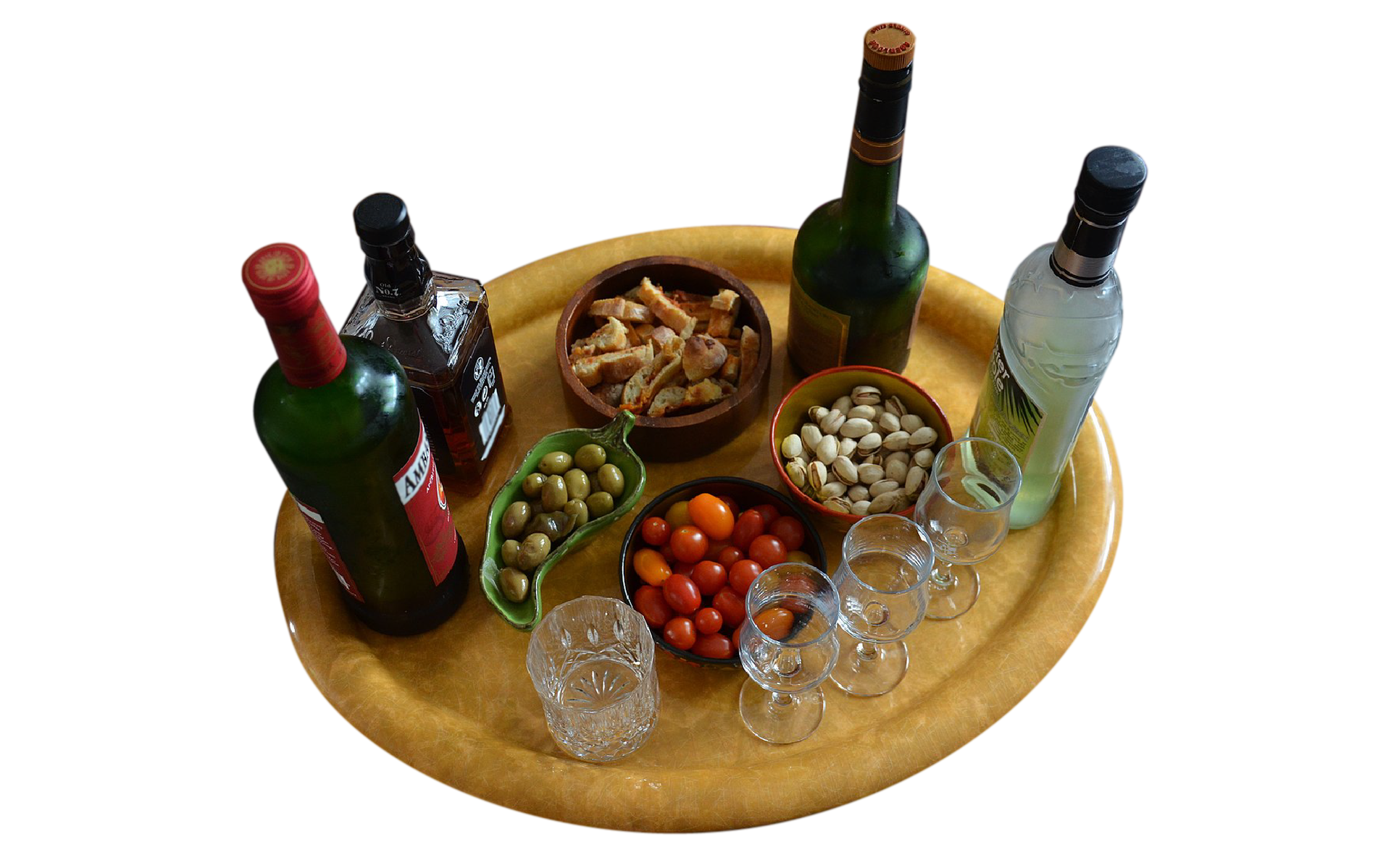 Na zdjęciu widać tacę, na której znajdują się: cztery butelki różnego rodzaju alkoholu, miseczka z pieczywem, miseczka z zielonymi oliwkami, miseczka z pomidorkami koktajlowymi, miseczka z pistacjami, trzy kieliszki na mocne alkohole i szklanka.