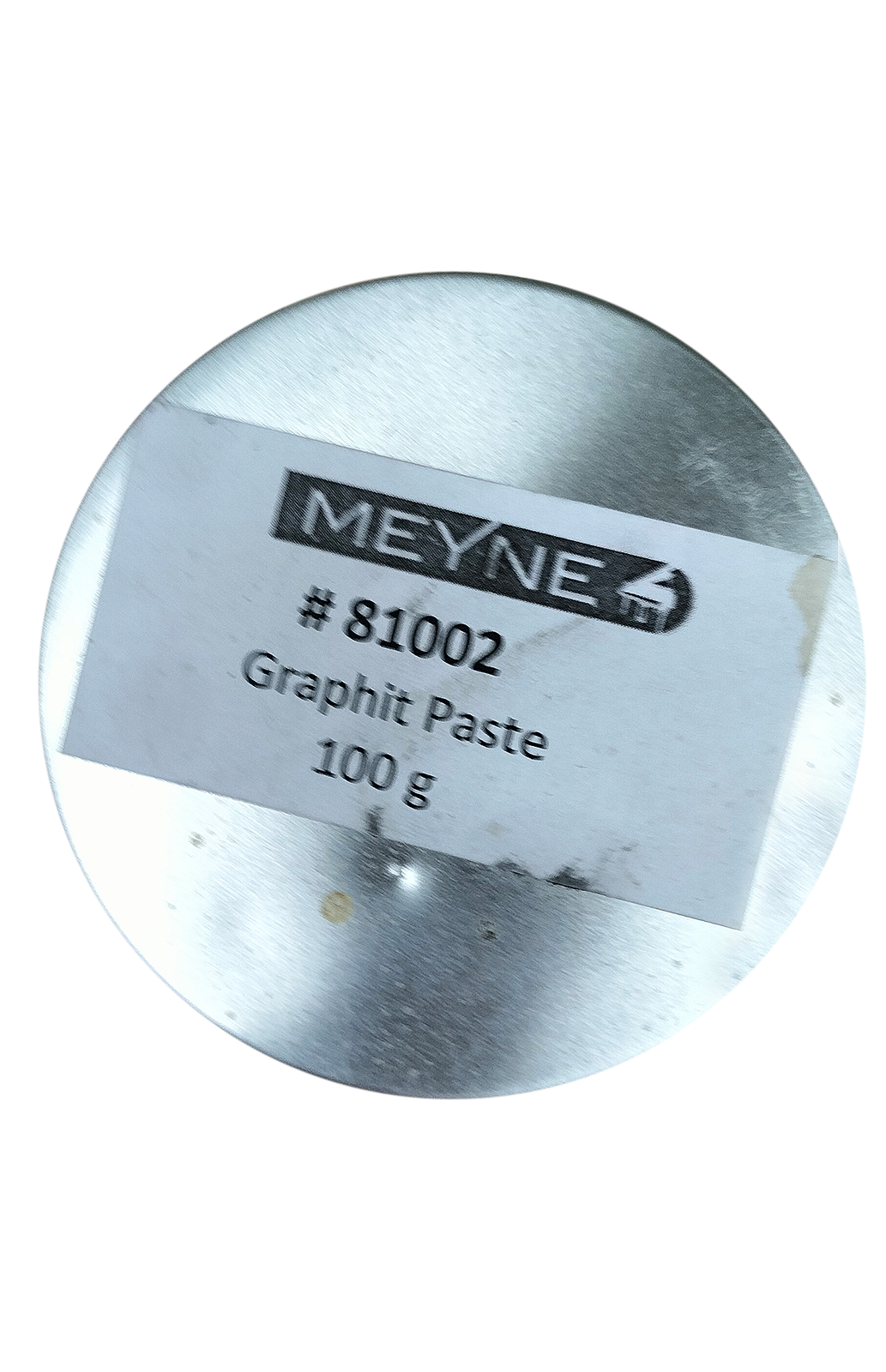 Zdjęcie przedstawia grafit stosowany do główek popychaczy, pilotów drewnianych, progów wiolinowych, mostków basowych. Widoczny jest okrągły metalowy pojemnik z białą etykietą z czarnymi napisami.