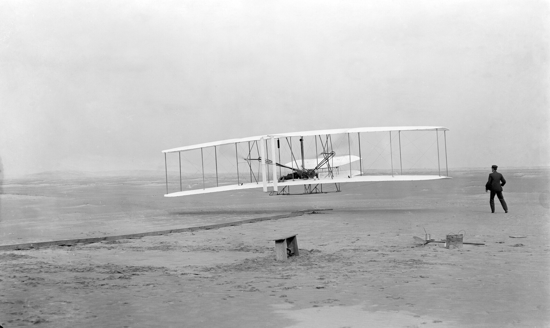 Pierwszy udany lot Wright Flyer Źródło: John T. Daniels, Pierwszy udany lot Wright Flyer, 1903, domena publiczna.