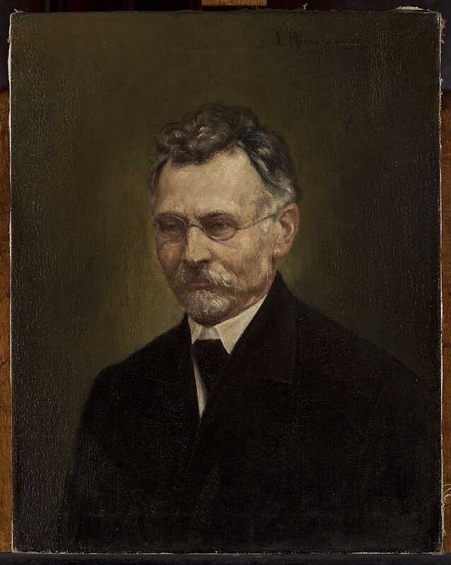 Obraz przedstawia portret dojrzałego mężczyzny. Mężczyzna ma pociągłą twarz. Jego włosy są krótkie, falujące, zaczesane ku górze. Mężczyzna ma niewielką brodę hiszpankę i wąsy. Nosi okulary w drucianej oprawce. Ubrany jest w garnitur, koszulę i krawat.