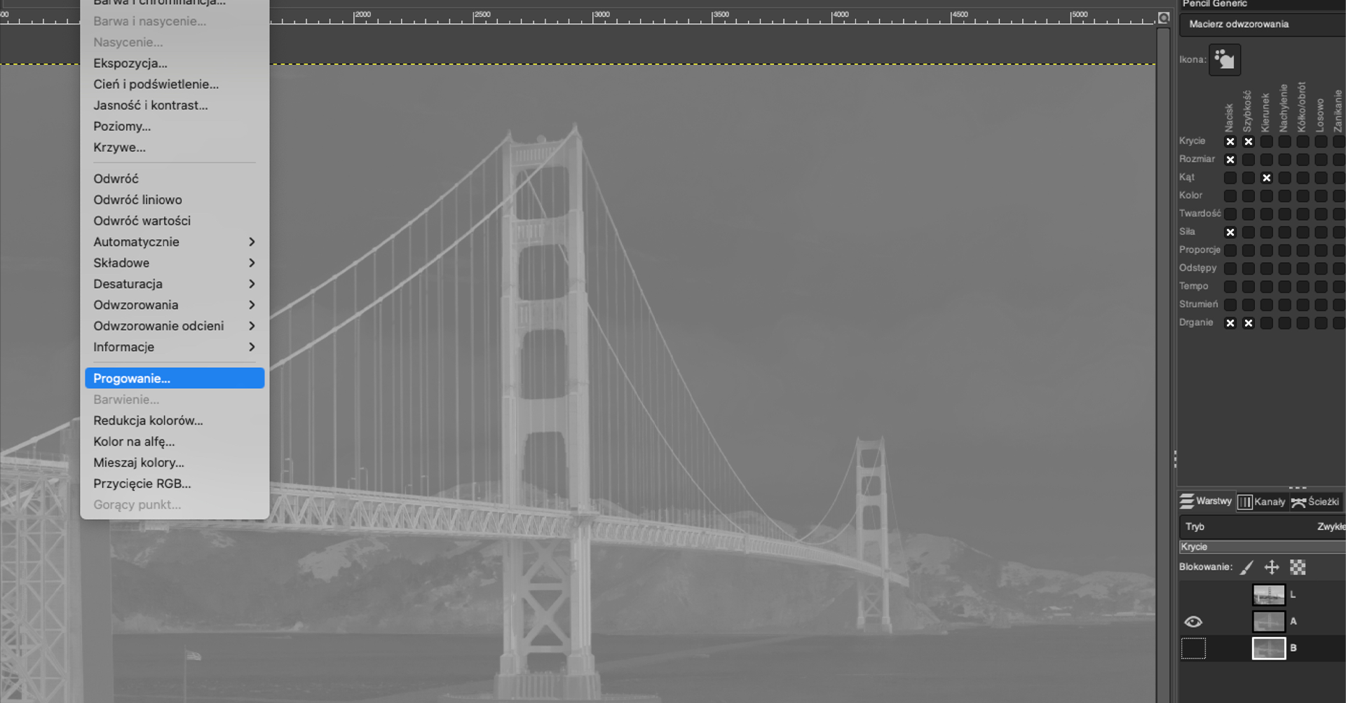 Ilustracja przedstawia wycinek okna w programie GIMP. Okno ma kolor szary, na górze i z lewej strony znajduje się podziałka z liczbami. Wewnątrz okna znajduje się czarno‑biała fotografia - most Golden Gate. Widoczne są tylko kontury mostu i brzegów w dwóch odcieniach szarości. Widoczna jest rozwinięta, pionowa lista z pozycjami: Balans kolorów…, Temperatura kolorów…, Barwa i chrominacja…, Barwa i nasycenie…, Nasycenie…, Ekspozycja…, Cień i podświetlenie…, Jasność i kontrast…, Poziomy…, Krzywe…, Odwróć, Odwróć liniowo, Odwróć wartości, Automatycznie, Składowe, Desaturacja, Odwzorowania, Odwzorowanie odcieni, Informacje, Progowanie…, Barwienie…, Redukcja kolorów…, Kolor na alfę…, Mieszaj kolory…, Przycięcie RGB…, Gorący punkt.  Z listy tej wybrana jest pozycja listy: Progowanie… . Po prawej stronie zdjęcia widoczny jest pasek menu programu.