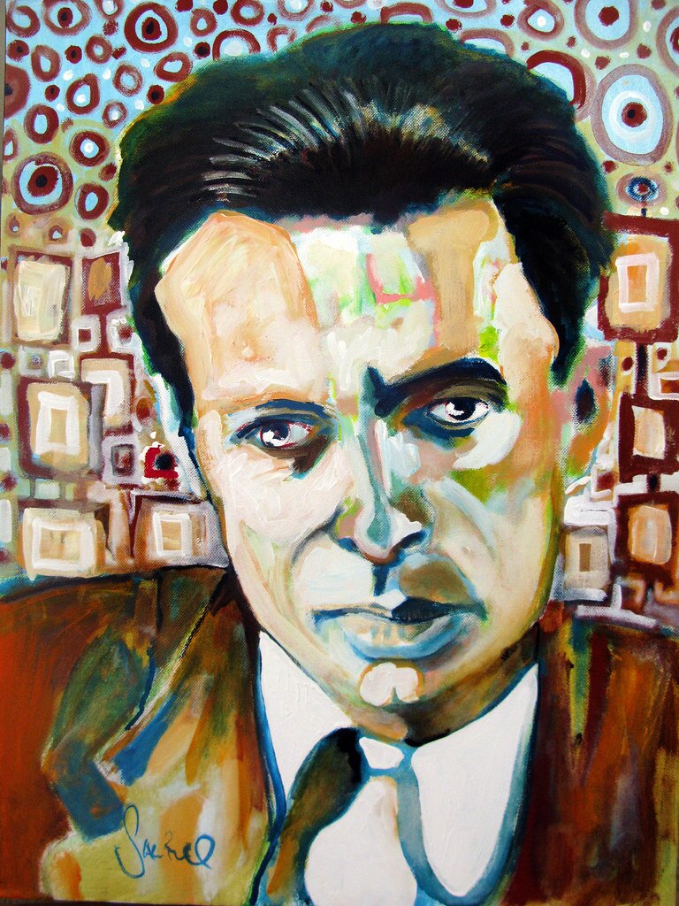 Obraz przedstawia portret młodego mężczyzny. Postać ukazana jest od piersi w górę. Prezentuje całą twarz, która jest pociągła. Mężczyzna ma wysokie czoło. Włosy krótkie, proste, zaczesane do góry. Ma wyraziste brwi, duże oczy. Nos jest duży i prosty, usta wyraziste. Ma gładko ogoloną twarz. Jest ubrany w koszulę i marynarkę. Pod szyją ma zawiązany krawat. W tle znajdują się owalne i prostokątne wzory.