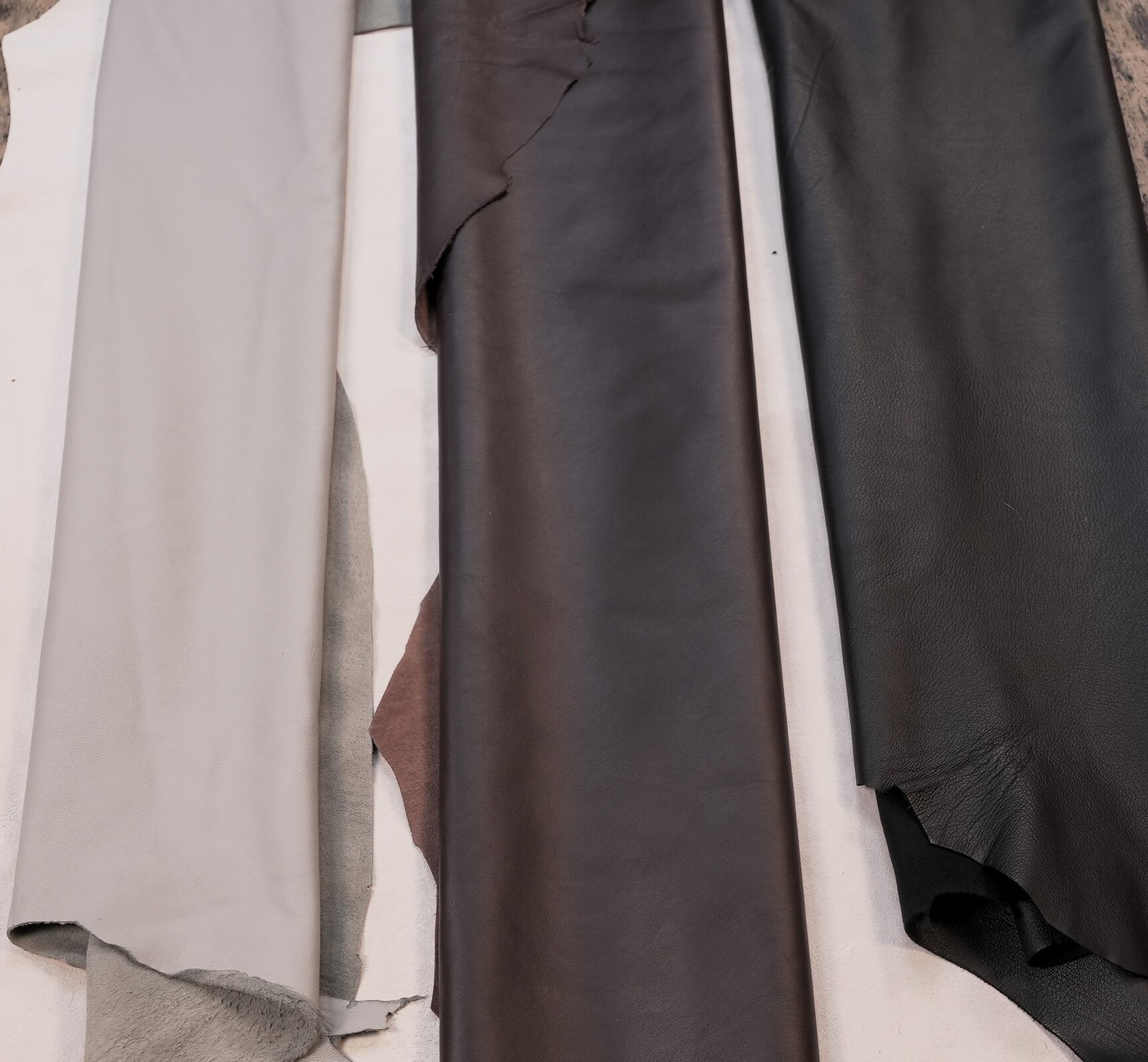 Na zdjęciu widoczne zwinięte i umieszczone obok siebie płaty skóry w odcieniach beżu, brązu i czerni.