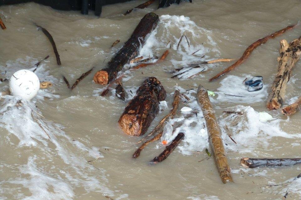 Ilustracja przedstawia brudny zbiornik wodny, w którym widoczne są śmieci, między innymi plastikowa butelka i piłka.