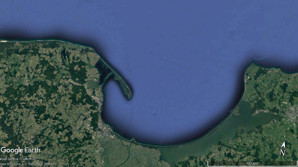 Zdjęcie satelitarne przedstawia wybrzeże mierzejowe. Ląd zaznaczony jest kolorem zielonym i brunatnym, a woda niebieskim. Od stałego lądu odchodzi długi, wąski pas ziemi wysunięty w głąb zatoki, powstały wskutek powstania mierzei odcinającej część zatoki od morza, w wyniku działania prądów przybrzeżnych. 