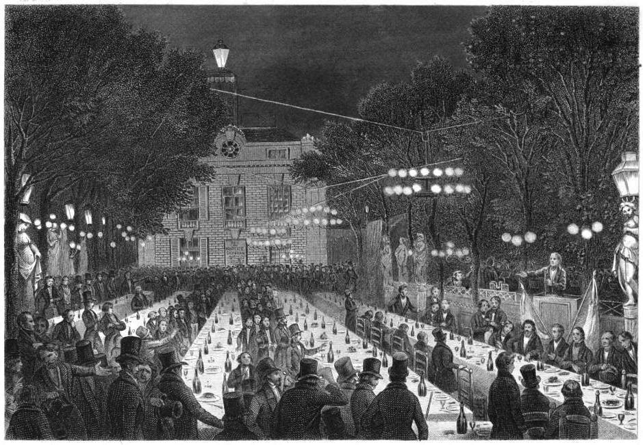 Ilustracja przedstawia ludzi zgromadzonych wokół długich stołów ustawionych w rzędy na świeżym powietrzu. Przy długich stołach nakrytych obrusami stoją zastawione talerze wraz z butelkami i kieliszkami. Stoły stoją w ogrodzie, równolegle do dwukondygnacyjnego budynku stojącego w tle. Nad stołami wiszą ogrodowe girlandy świetlne. Przy stołach zasiadają na krzesłach goście, inni stoją obok. Wśród osób dominują mężczyźni ubrani są we fraki, płaszcze i wysokie czarne kapelusze. Wzdłuż alei stoją latarnie o ozdobnych, rzeźbionych cokołach.