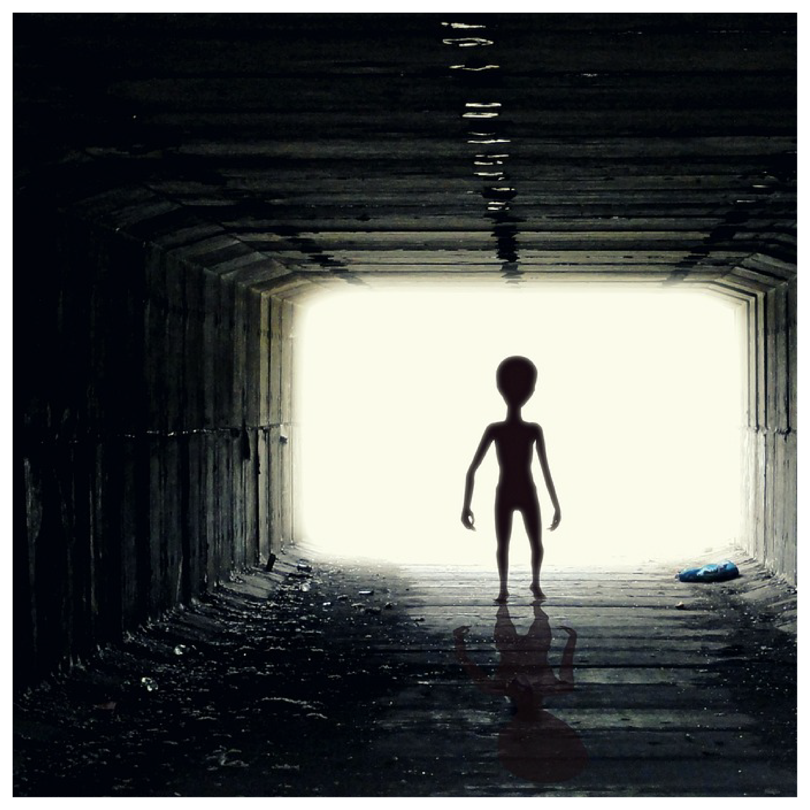 Ilustracja przedstawia tunel, w którym stoi kosmita.