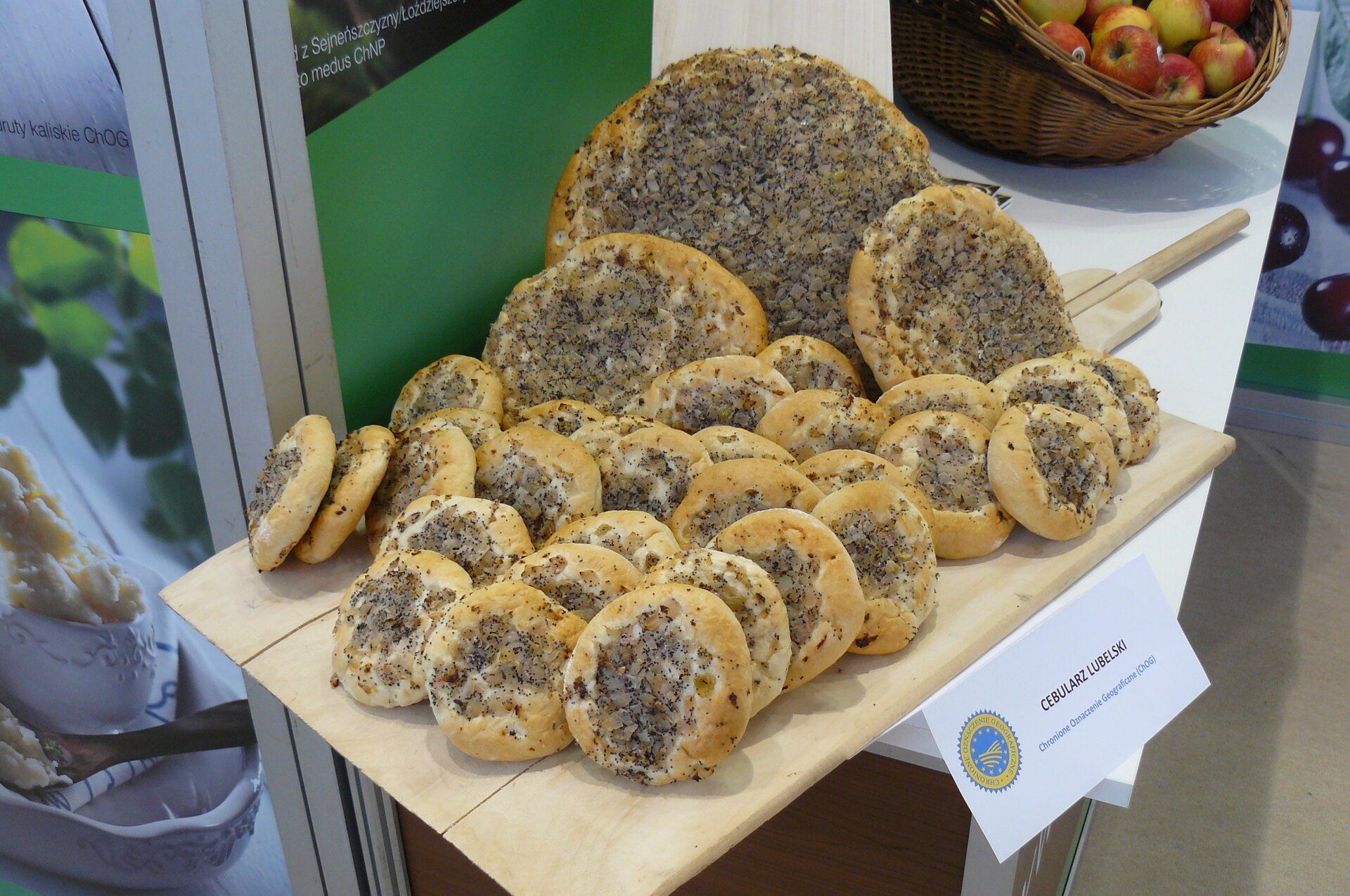 Zdjęcie przedstawia tradycyjne wyroby spożywcze. Na stoliku znajdują się cebularze. 