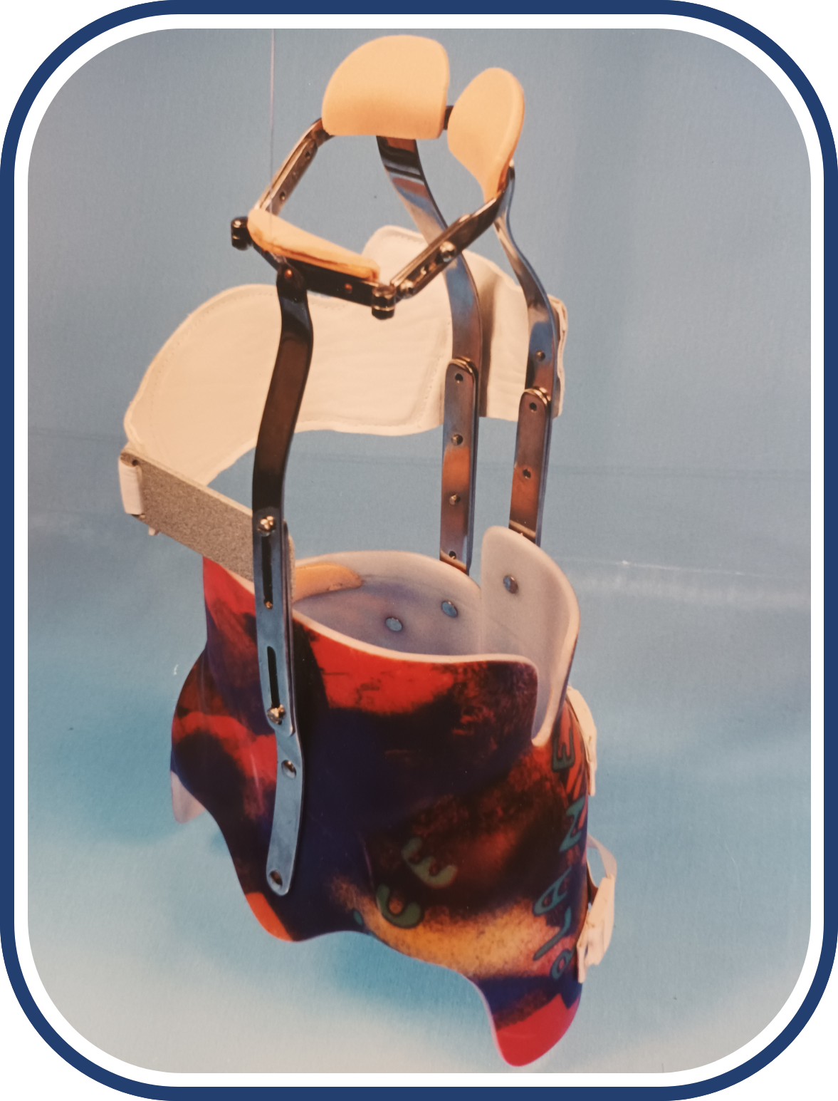 Zdjęcie przedstawia gorset z profilowanym koszem biodrowym. Na wysokości klatki piersiowej użytkownika znajduje się szyna sięgająca do jego brody i okalająca szyję oraz wstawka po lewej stronie okalająca żebra. Z tyłu poprowadzone są dwie szyny na szerokości kręgosłupa pacjenta, które sięgają do podstawy jego czaszki. Pomiędzy łopatkami jest umieszczona dodatkowa wstawka stabilizująca.