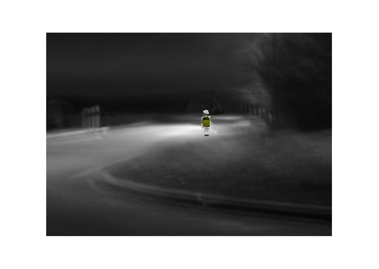 Fotografia edytowana. Ciemna noc, widać tylko oświetloną drogę, na której stoi tyłem dziecko z plecakiem na plecach. Nastrój zdjęcia jest tajemniczy, wywołuje lęk.