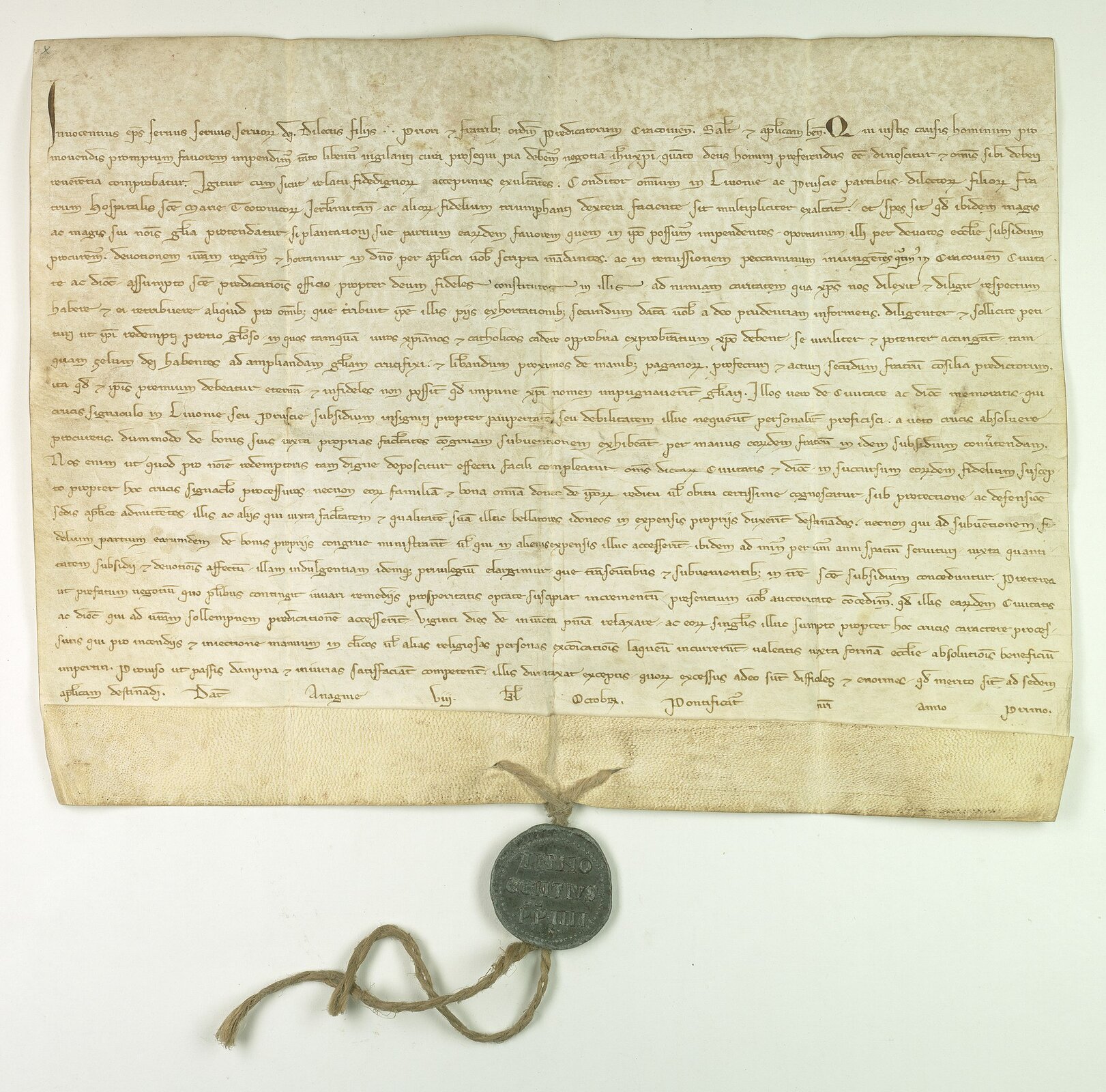 Ilustracja przedstawia średniowieczny dokument. Dokument sporządzony został na pergaminie pismem odręcznym. Dla jego uwierzytelbnienia ma przywieszoną pieczęć lakową.