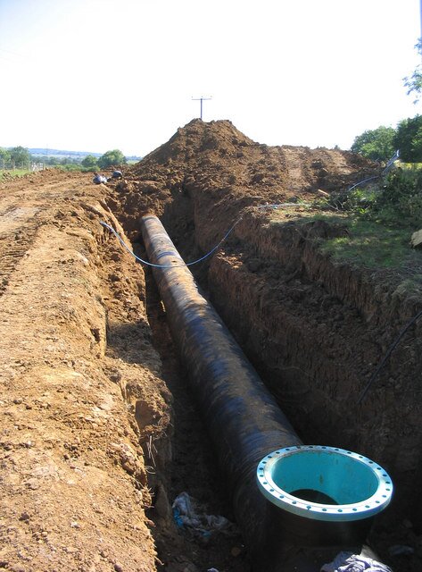 Zdjęcie przedstawia rów melioracyjny, w którym widać rurę.