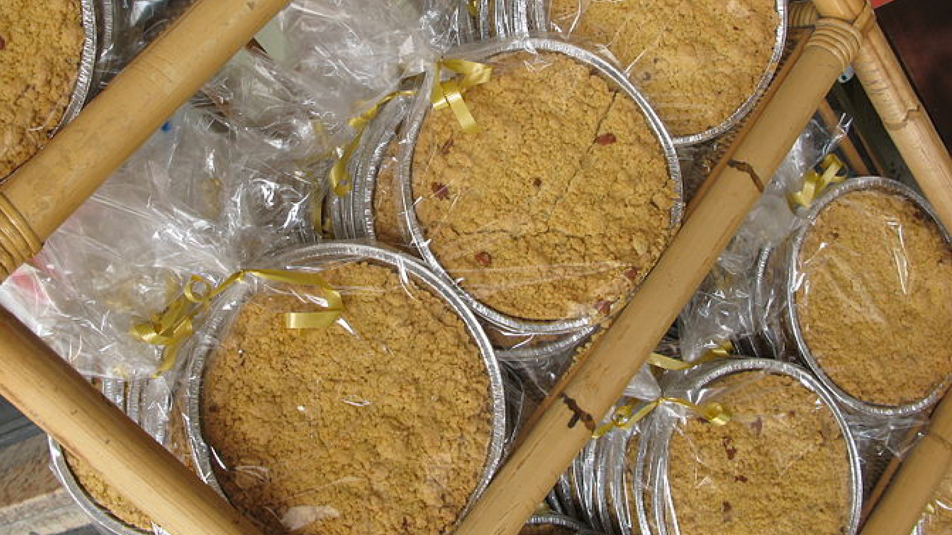 Zdjęcie przedstawia kilka kruchych, włoskich ciast Sbrisolona. Każde ciasto znajduje się w osobnej aluminiowej foremce.