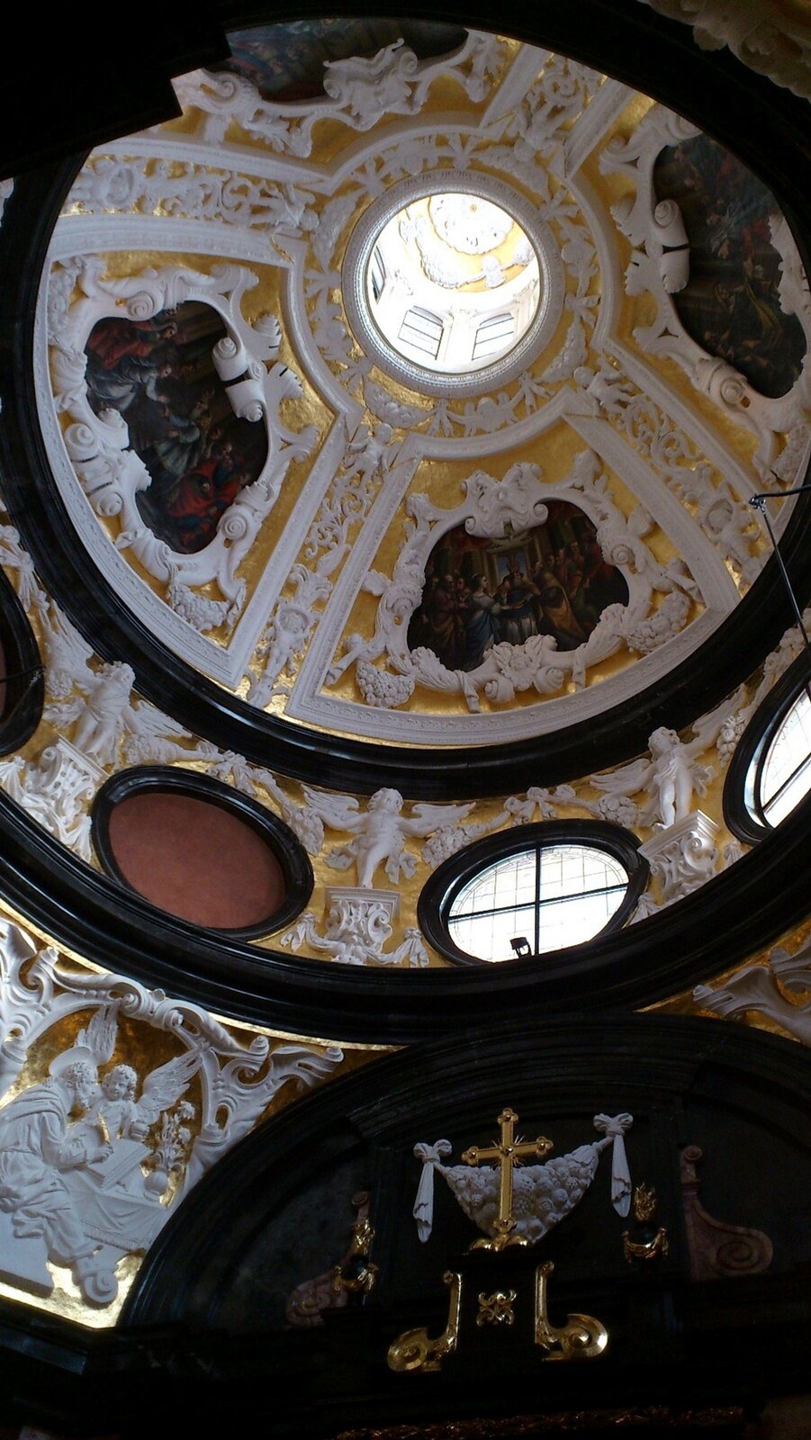 Ilustracja przedstawia zdjęcie kopuły Kaplicy Wazów na Wawelu. Na zdjęciu ukazane są freski oraz liczne zdobienia.