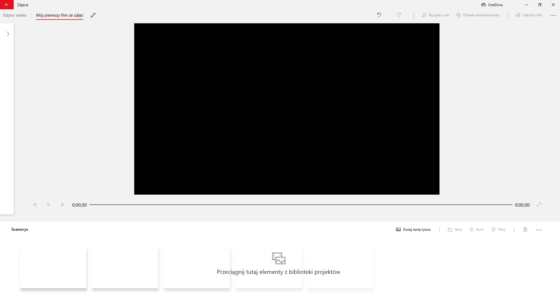 Na zrzucie ekranu przedstawiono widok ze sposobu edycji filmu w aplikacji Edytor Wideo. W górnej części okna aplikacji znajduje się ścieżka z wybranymi zakładkami: edytor wideo, mój pierwszy film ze zdjęć. Za nią widoczny jest przycisk z rysunkiem ołówka. Po prawej stronie aplikacji widoczne są przyciski: strzałka z grotem skierowanym w lewo, strzałka z grotem skierowanym w prawo, muzyka w tle, dźwięk niestandardowy, zakończ film i trzy kropki rozwijające więcej opcji. W centralnej części ekranu widać okno edycji filmu. Pod oknem umieszczony jest suwak pokazujący czas trwania.Pod suwakiem znajduje się sekcja: scenorys. W sekcji widoczne są białe prostokątne miejsca przypominające klatki filmowe. Nad nimi widoczny jest napis: przeciągnij tutaj elementy z biblioteki projektów.W prawym górnym rogu sekcji scenorysu umieszczone są przyciski: dodaj kartę tytułu, tekst, ruch, filtry, kosz, oraz trzy kropki po naciśnięciu których pojawia się więcej opcji.