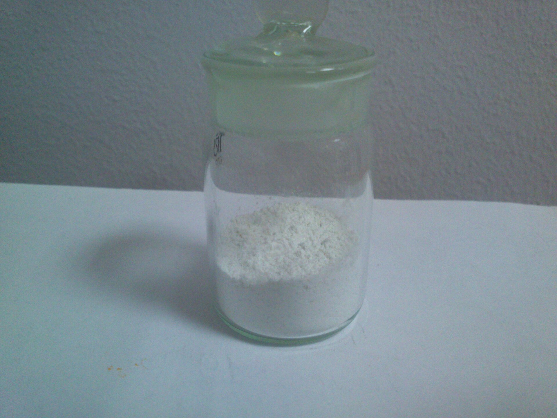 Zdjęcie przedstawia fiolkę z białym proszkiem, będącym siarczkiem cynku.