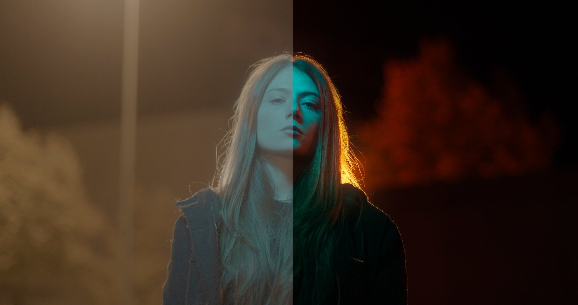 Fotografia ukazująca młodą kobietę o długich, blond włosach. Ubrana jest w czarną koszulkę oraz bluzę. Kobieta przedstawiona jest od połowy tułowia w górę. Znajduje się na ciemnej ulicy, która oświetlona jest przez jedną lampę uliczną. W tle znajdują się drzewa oraz zarys wysokiego budynku. Zdjęcie zostało przedzielone na pół, pionową linią. Lewa strona fotografii jest rozjaśniona, a kolory nieco wyblakłe. Prawa strona zaś jest ciemniejsza, jednak z barw wydobyto ich głębię.