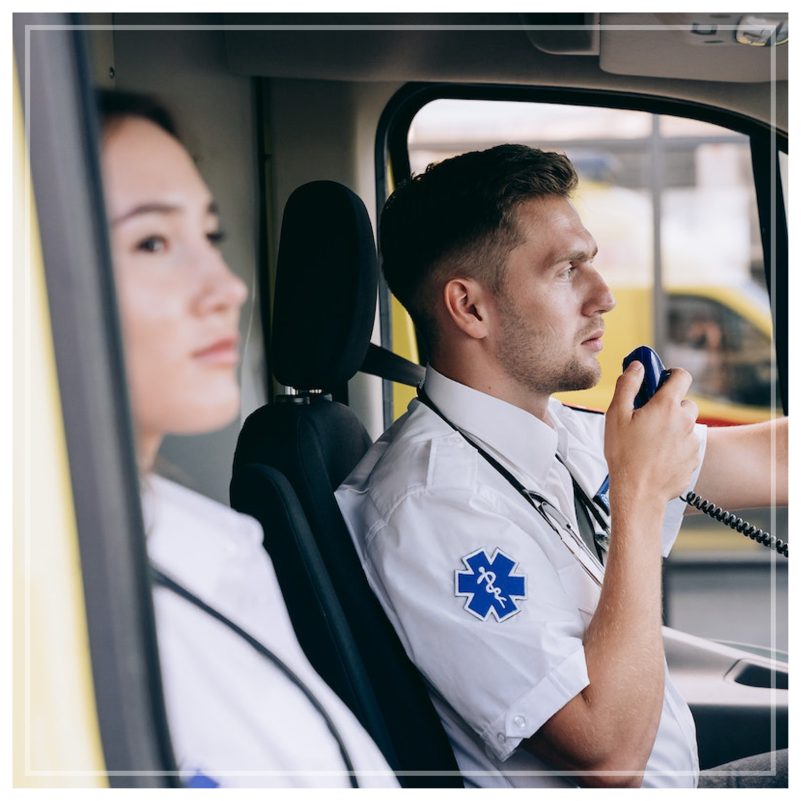 Na zdjęciu znajdują się lekarz i lekarka pogotowia medycznego. Lekarz prowadzi auto i odbiera połączenie. 