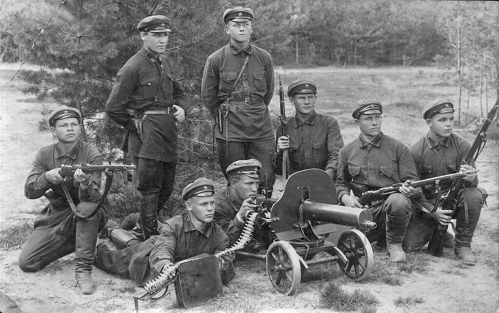 Zdjęcie przedstawia niewielki, ośmioosobowy oddział żołnierzy Armii Czerwonej. Mężczyźni pozują do zdjęcia z karabinami, karabinem maszynowym, na polanie, wśród drzew.