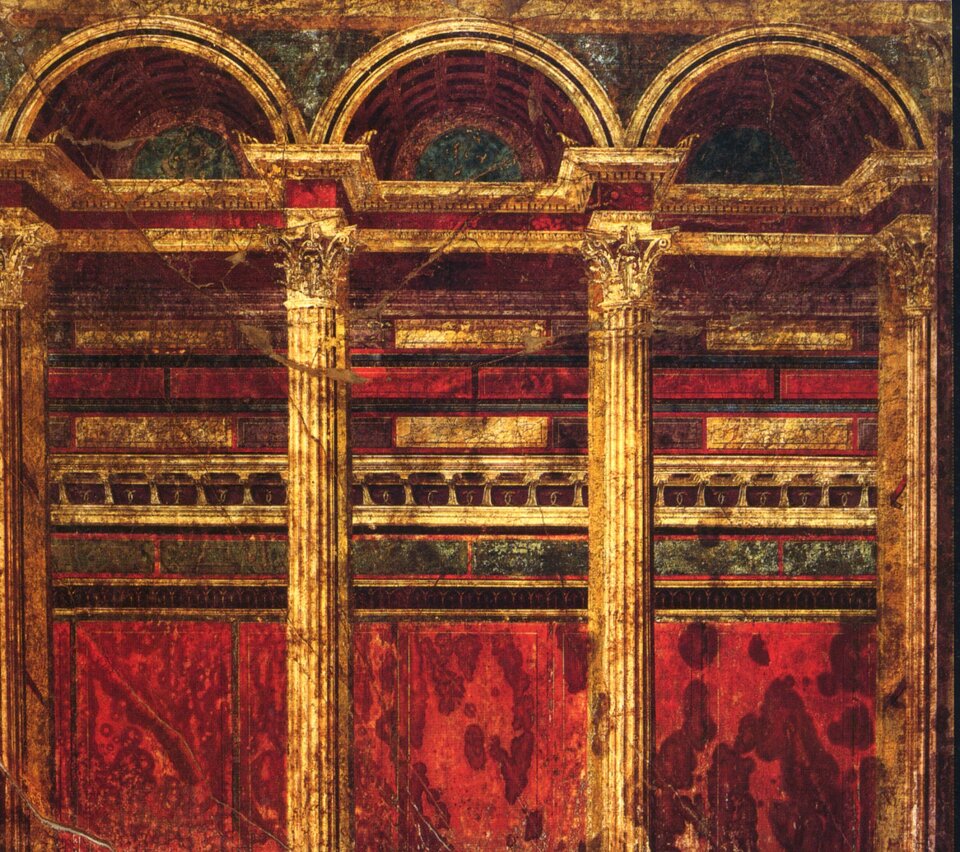 Ilustracja przedstawia wnętrze Willi Tajemnic w Pompejach. Ściana została podzielona na trzy pionowe strefy, w których dominują malowane kompozytowe kolumny, belkowania i nisze, tworzące iluzję głębi przestrzeni. Kompozycja opiera się na kontrastach kolorystycznych (czerwień, odcienie złotego brązu) i na układzie symetrycznym.