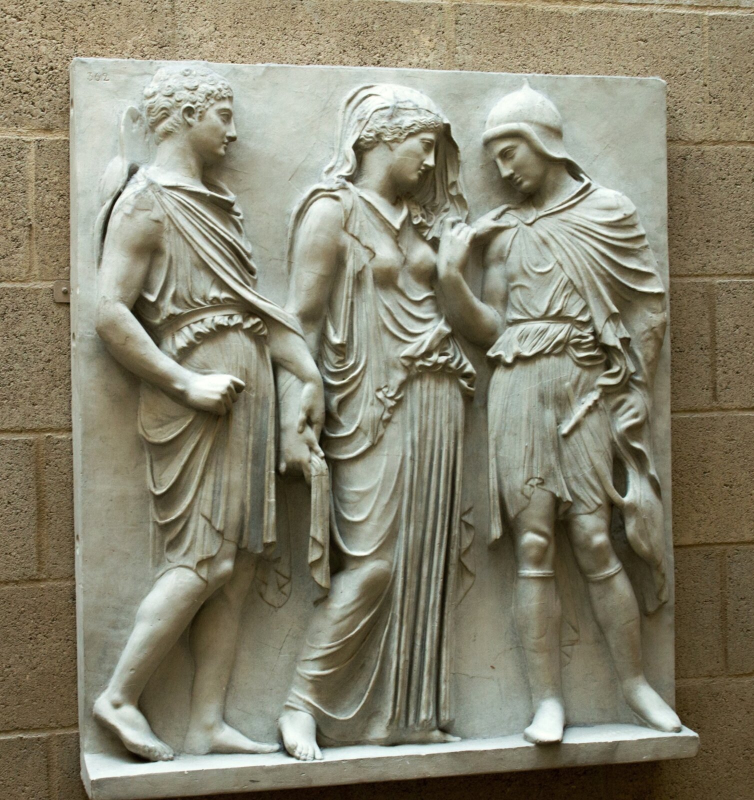 Płaskorzeźba przedstawiająca Orfeusza patrzącego na Eurydykę, podczas gdy Hermes zabiera ją z powrotem do krainy cieni. Postać stojącą po lewej stronie patrzącego na płaskorzeźbę można rozpoznać po nakryciu głowy podróżnych (petasos) oraz sukmanie (chlamys) przewieszonej przez prawie ramię. Jest ubrany w krótką tunikę przewiązaną w pasie. Swoją prawą dłonią trzyma za prawy nadgarstek postaci kobiecej, która jest centralną postacią tego dzieła. Stoi ona opierając swój ciężar ciała na lewej nodze. Jej lewa dłoń jest uniesiona na wysokość ramienia mężczyzny stojącego z prawej strony, jakby chciała go pocieszyć. Kobieta jest ubrana w klasyczną szatę zapiętą na ramionach i przewiązaną w pasie. Jej strój uzupełnia welon, który osłania jej twarz z oczami zwróconymi ku dołowi. Obie postacie mają założone sandały. Ostatnia postać, mężczyzna, stoi po prawej stronie patrzącego na dzieło. Jego dłoń unosi się na wysokość ramienia, by dotknąć dłoni kobiety. Nosi on wysokie buty, a na głowie ma spiczasty tracki kapelusz, który akcentuje jego północne pochodzenie. W lewej dłoni trzyma lirę. 