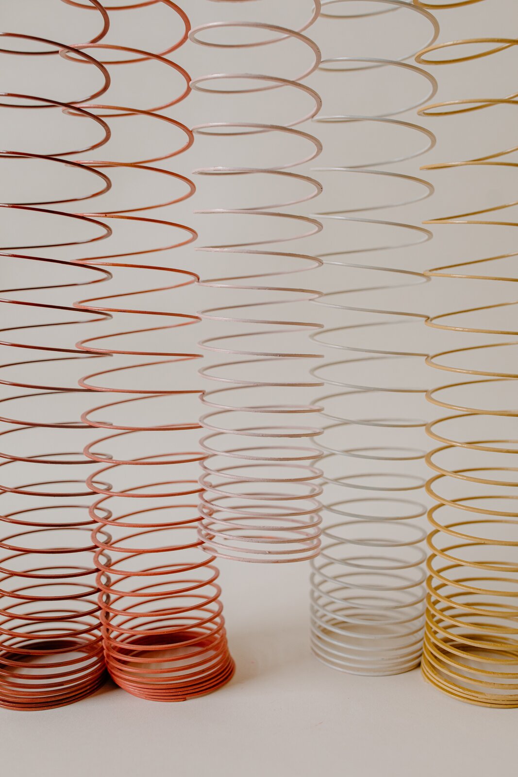 Rys. 1. Na zdjęciu przedstawiono długie sprężyny‑zabawki. Na długości sprężyn widoczne są miejsca, gdzie ich zwoje leżą blisko siebie i takie, gdzie są one od siebie oddalone.