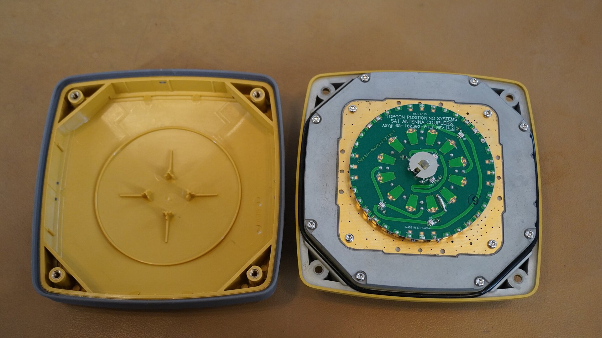 Na zdjęciu przedstawiono wnętrze odbiornika GNSS widoczne po zdjęciu obudowy. W środku znajduje się okrągła płytka będąca elementem anteny GBS służącej do odbioru sygnału z satelity, zaś znajdujący się w centralnej części pierścień to antena bluetooth. Na lewo znajduje się zdemontowana obudowa.