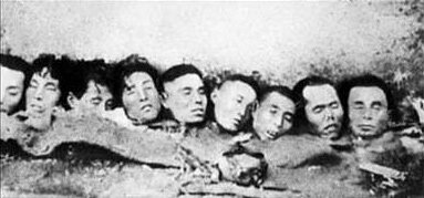Zdjęcie przedstawia dziewięć odciętych ludzkich głów leżących pod ścianą.